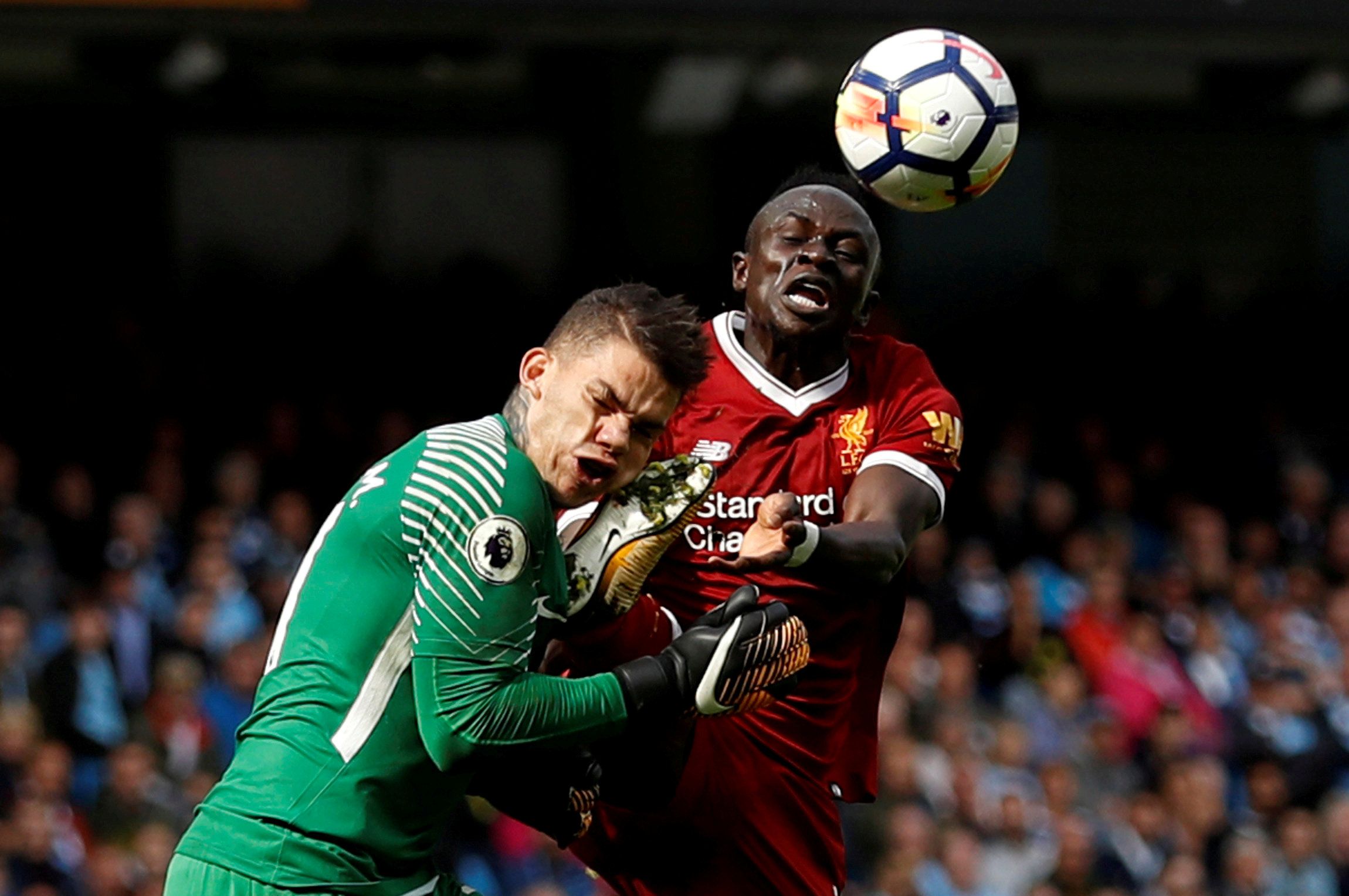 Liverpool's Sadio Mane clashes with Man City's Ederson