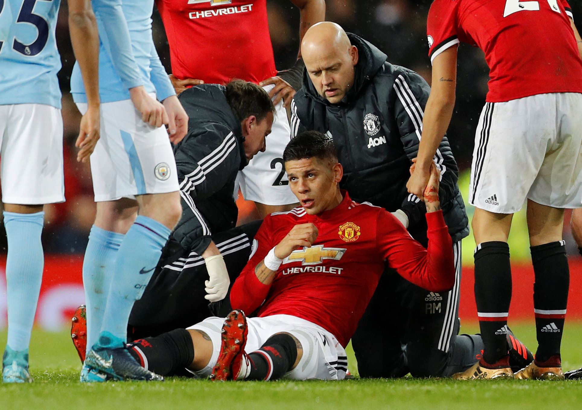 Soccer Football - Premier League - Manchester United vs Manchester City - Old Trafford, Manchester, Britain - December 10, 2017   Manchester United's Marcos Rojo receives medical attention after sustaining an injury                 REUTERS/Darren Staples    EDITORIAL USE ONLY. No use with unauthorized audio, video, data, fixture lists, club/league logos or "live" services. Online in-match use limited to 75 images, no video emulation. No use in betting, games or single club/league/player publicat