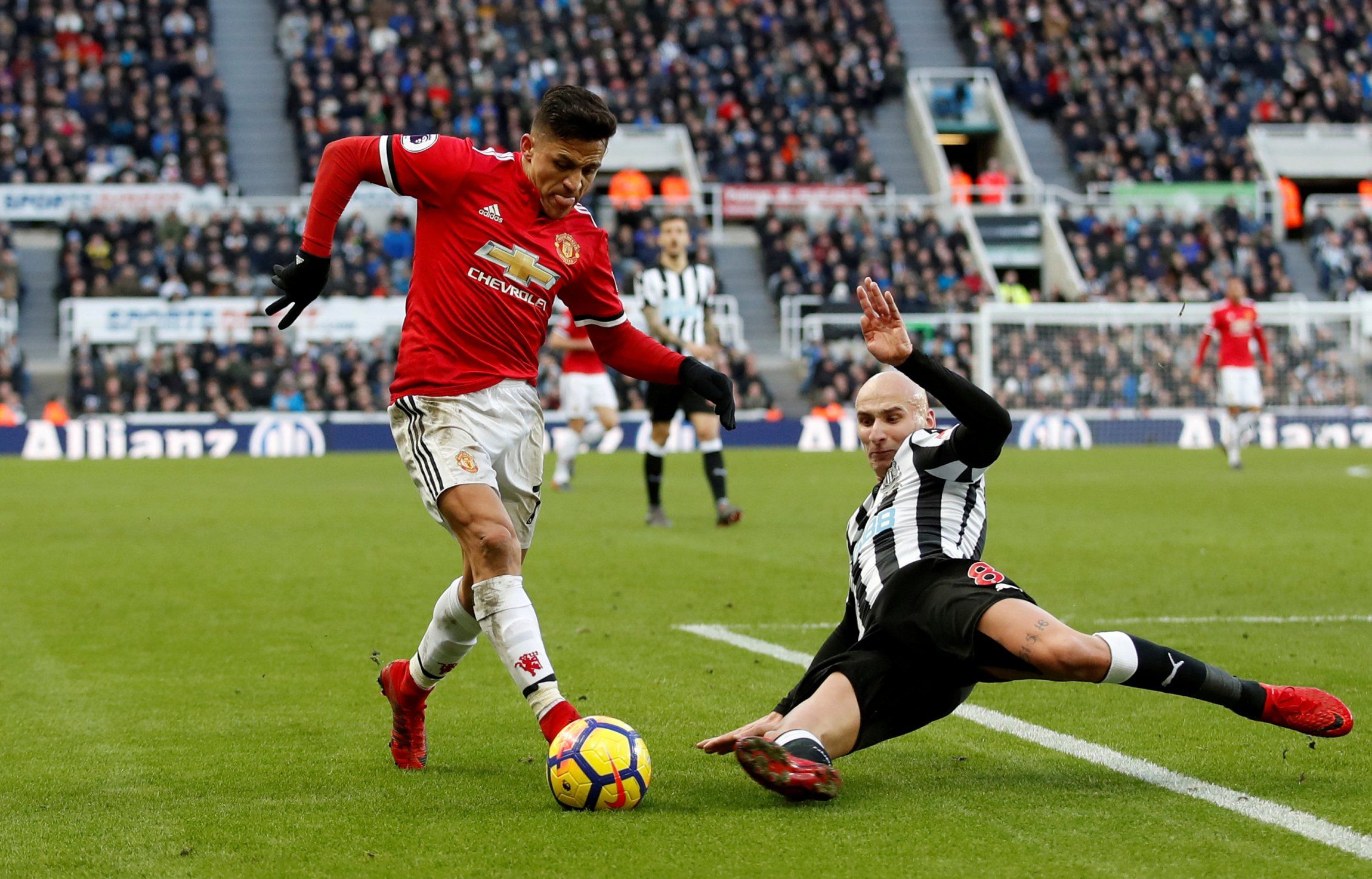 Newcastle midfielder Jonjo Shelvey tackles Alexis Sanchez