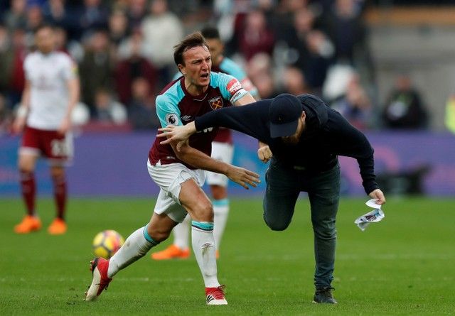 Soccer Football - Premier League - West Ham United vs Burnley - London Stadium, London, Britain - March 10, 2018   West Ham United's Mark Noble clashes with a fan who has invaded the pitch    Action Images via Reuters/Peter Cziborra    EDITORIAL USE ONLY. No use with unauthorized audio, video, data, fixture lists, club/league logos or 