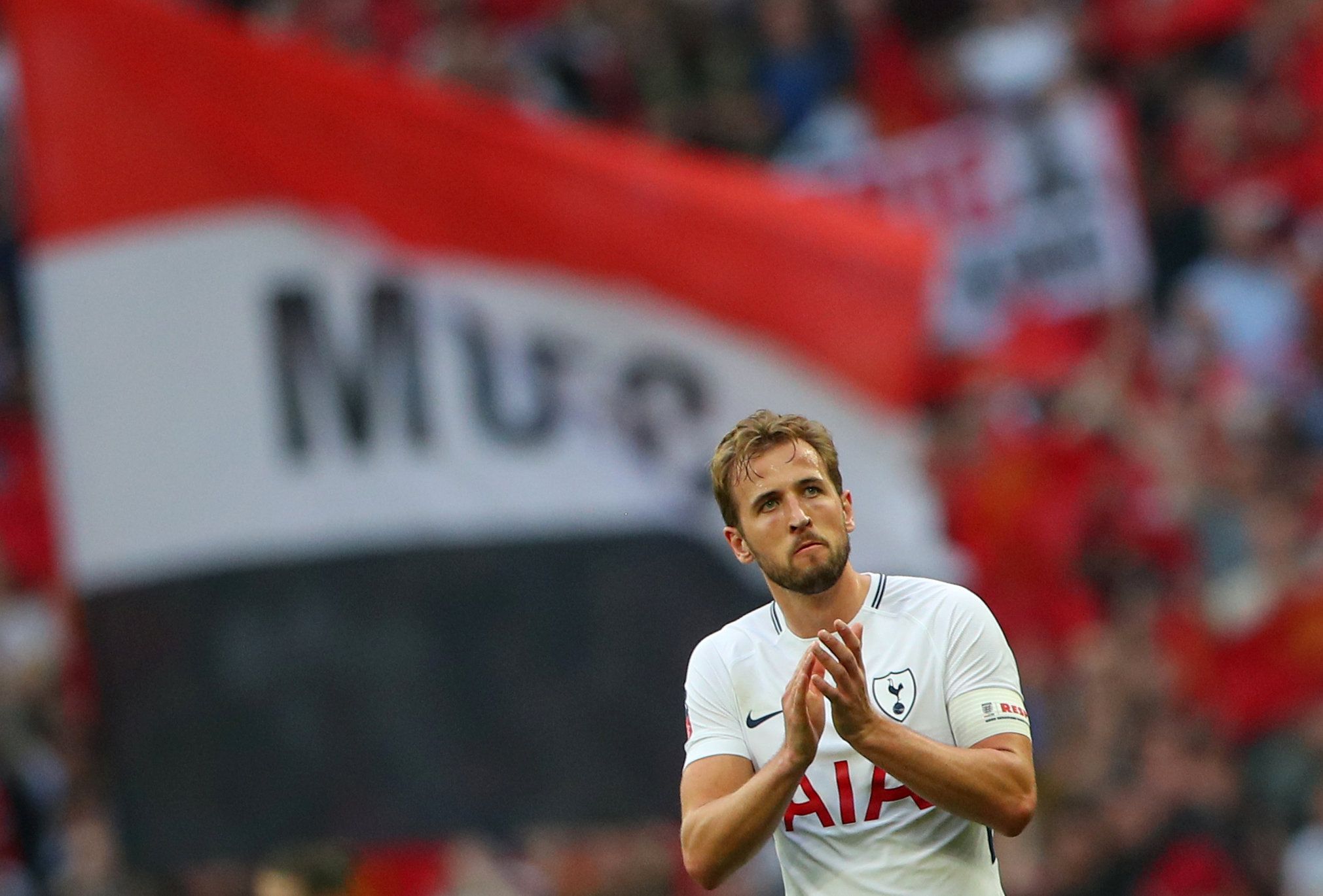 Harry Kane in front of a Manchester United flag