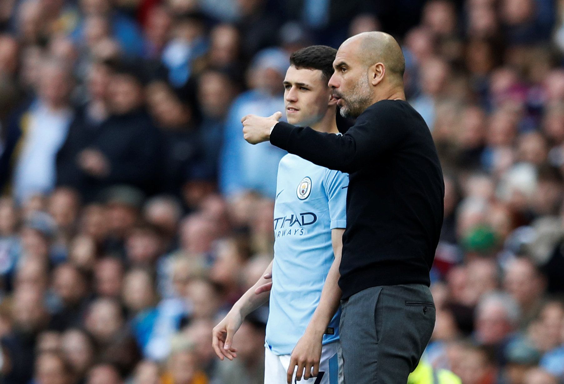 Manchester City boss Pep Guardiola gives Phil Foden instructions on the touchline