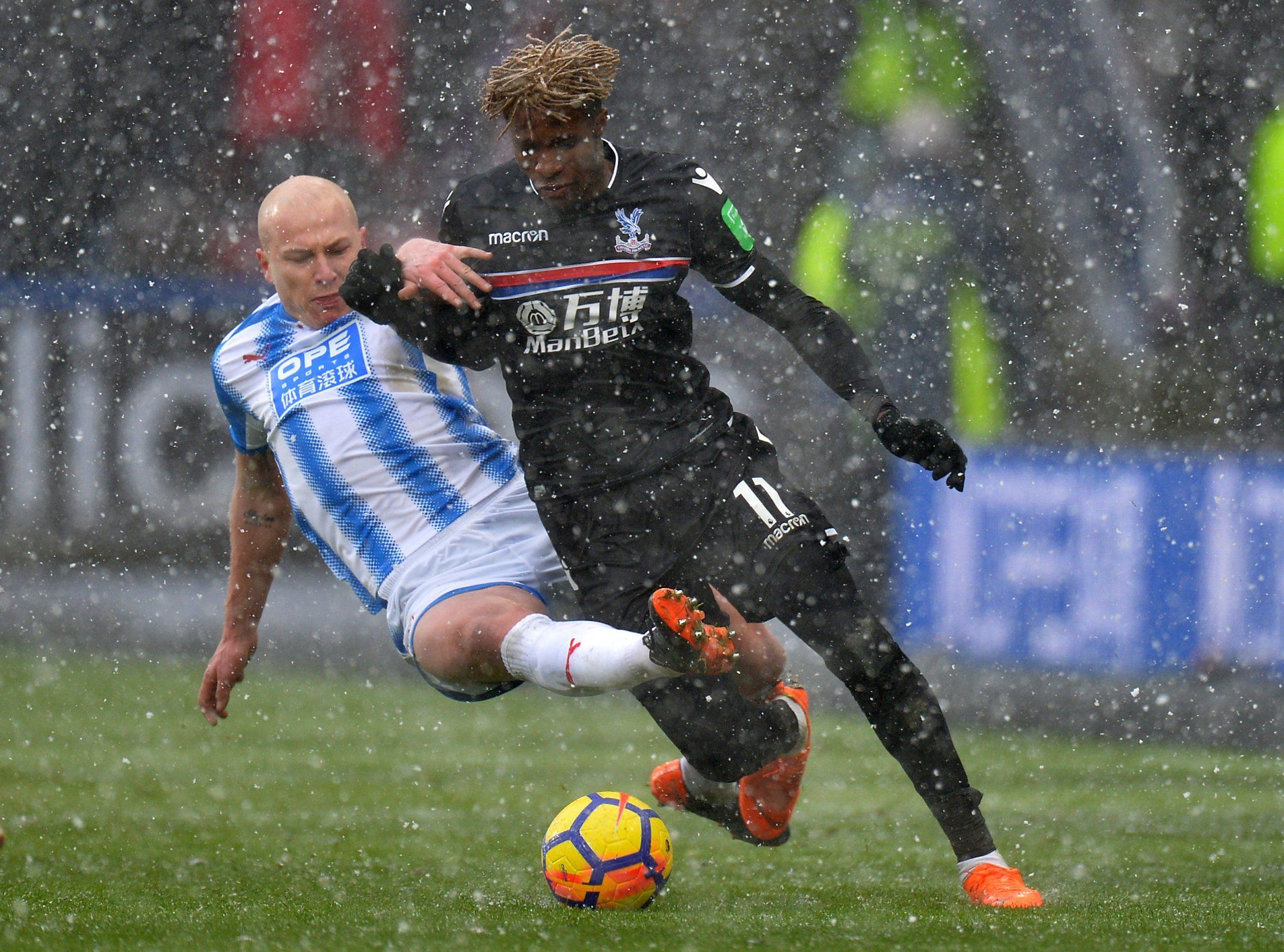 Aaron Mooy in action with Wilfried Zaha