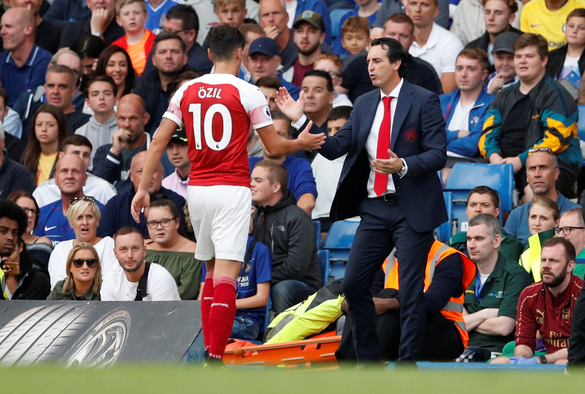Soccer Football - Premier League - Chelsea v Arsenal - Stamford Bridge, London, Britain - August 18, 2018  Arsenal's Mesut Ozil with manager Unai Emery after being substituted off  Action Images via Reuters/John Sibley  EDITORIAL USE ONLY. No use with unauthorized audio, video, data, fixture lists, club/league logos or "live" services. Online in-match use limited to 75 images, no video emulation. No use in betting, games or single club/league/player publications.  Please contact your account rep