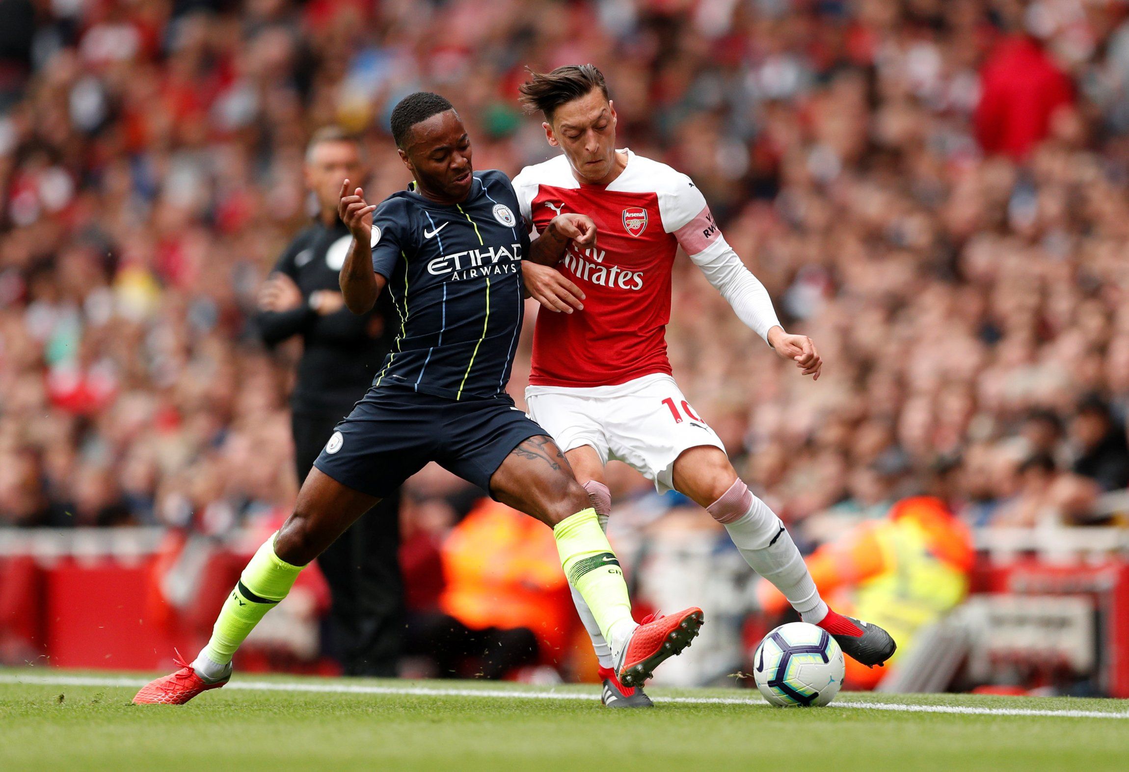 Raheem Sterling challenges Mesut Ozil in Manchester City's clash against Arsenal