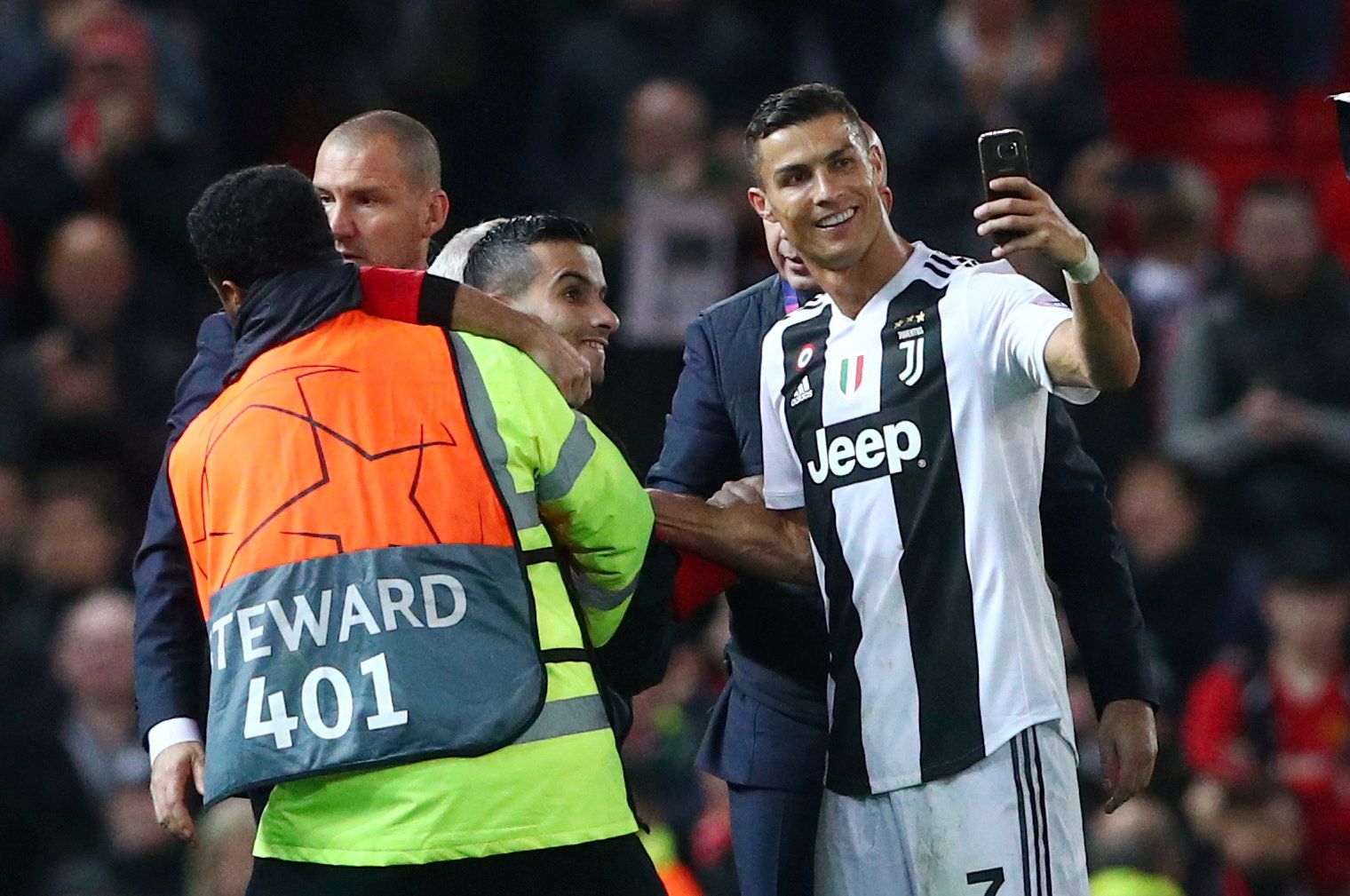 Soccer Football - Champions League - Group Stage - Group H - Manchester United v Juventus - Old Trafford, Manchester, Britain - October 23, 2018  Juventus' Cristiano Ronaldo takes a selfie as stewards apprehend a pitch invader after the match               REUTERS/Hannah McKay     TPX IMAGES OF THE DAY