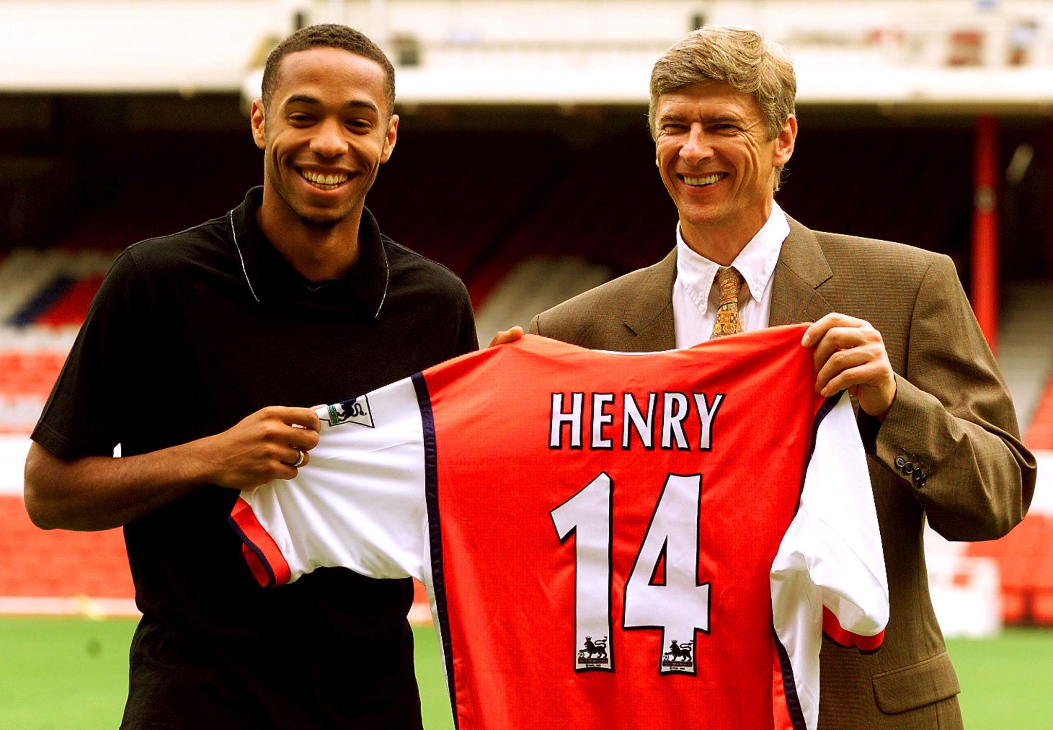 FILE PHOTO: Soccer Football - French international striker Thierry Henry smiles with manager Arsene Wenger as they show off his new number 14 Arsenal shirt at Highbury, London, Britain - August 3, 1999 REUTERS/Dylan Martinez/File Photo