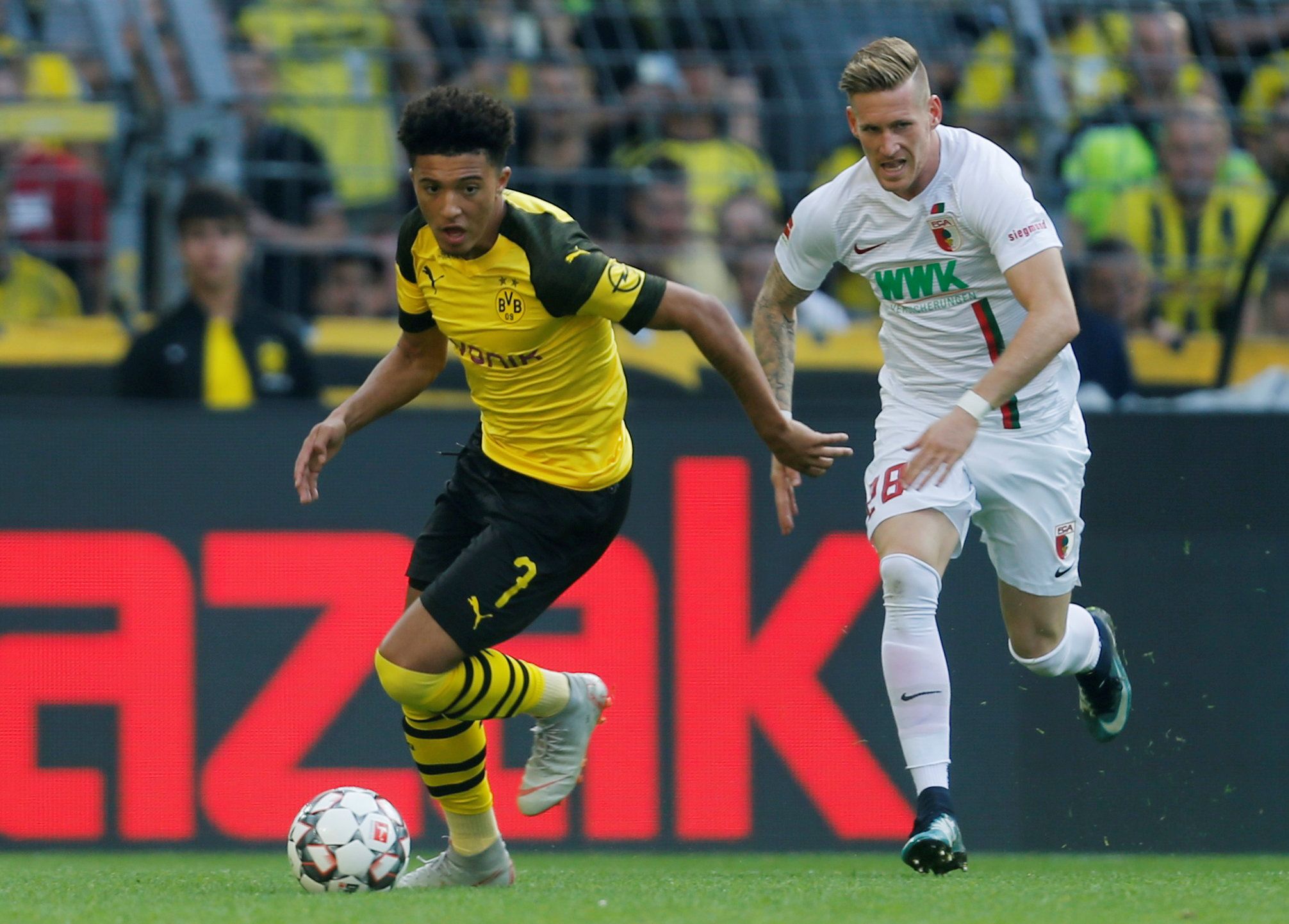 Jadon Sancho runs with the ball for Borussia Dortmund against Augsburg