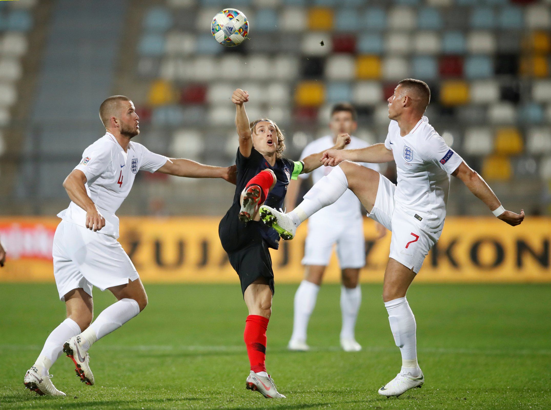 Luka Modric challenges two England players for the ball
