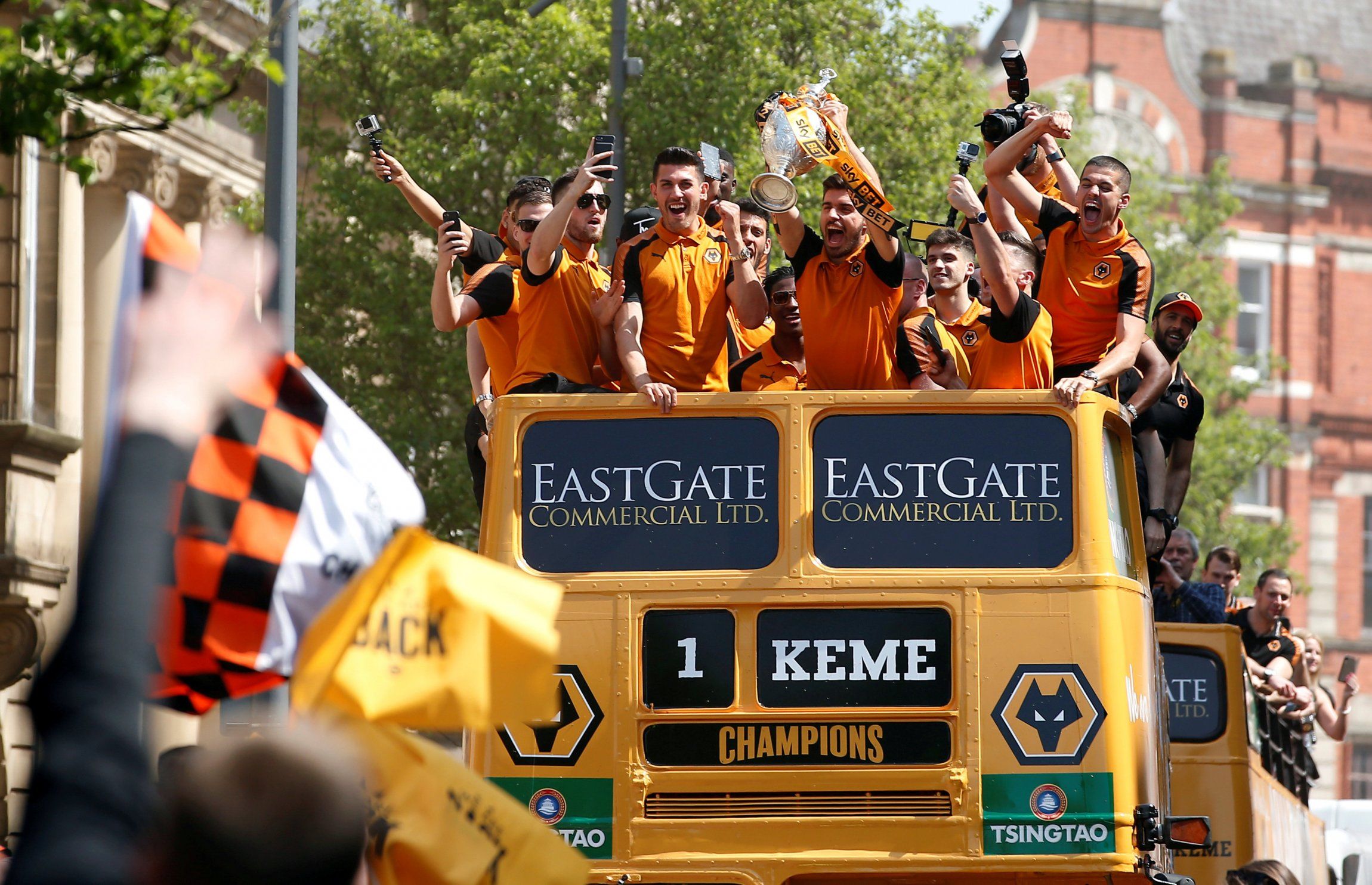 Wolverhampton Wanderers' Ruben Neves celebrates with the Championship trophy on the open top bus during the parade