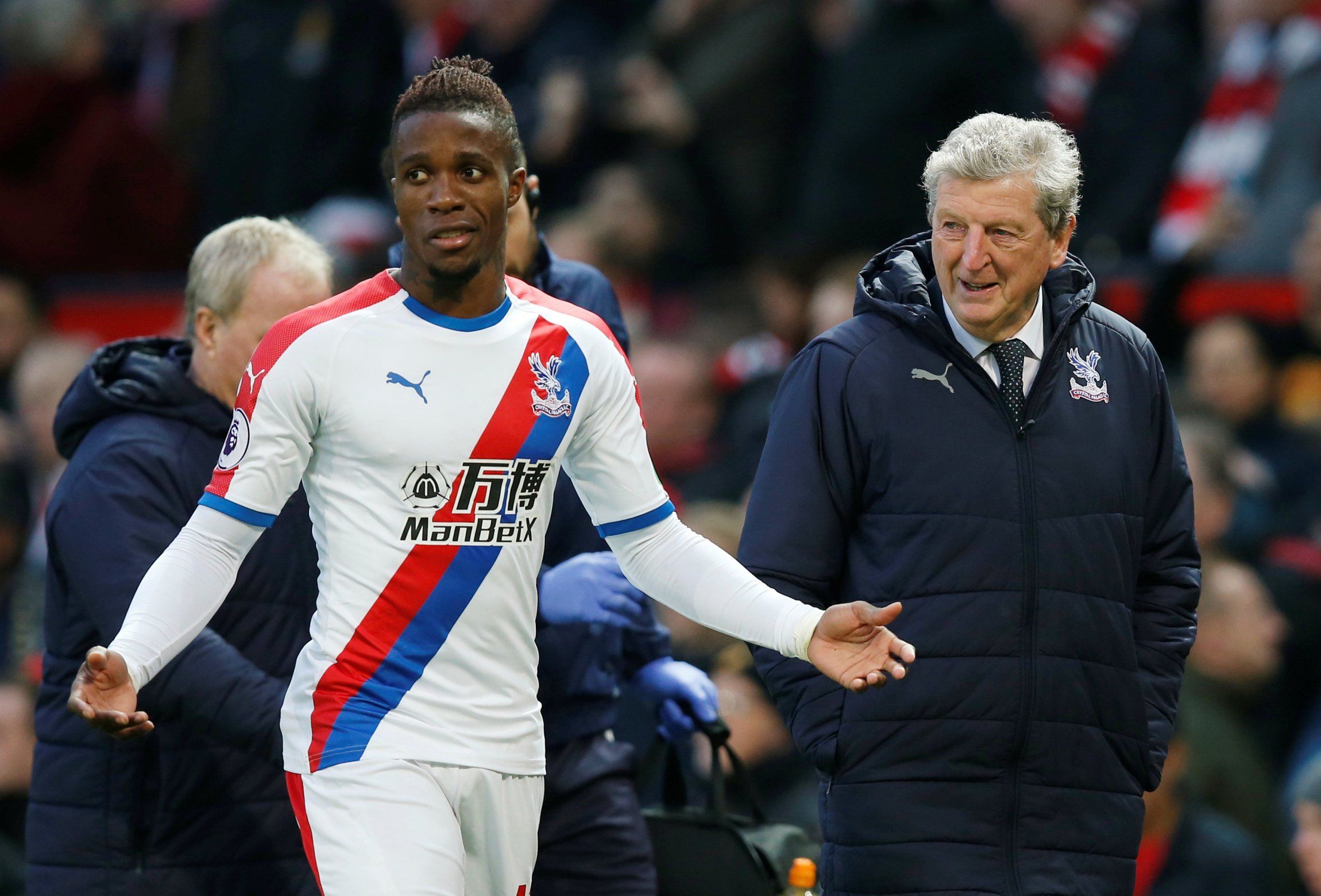 Crystal Palace's Wilfried Zaha and manager Roy Hodgson in discussion at half time at Manchester United