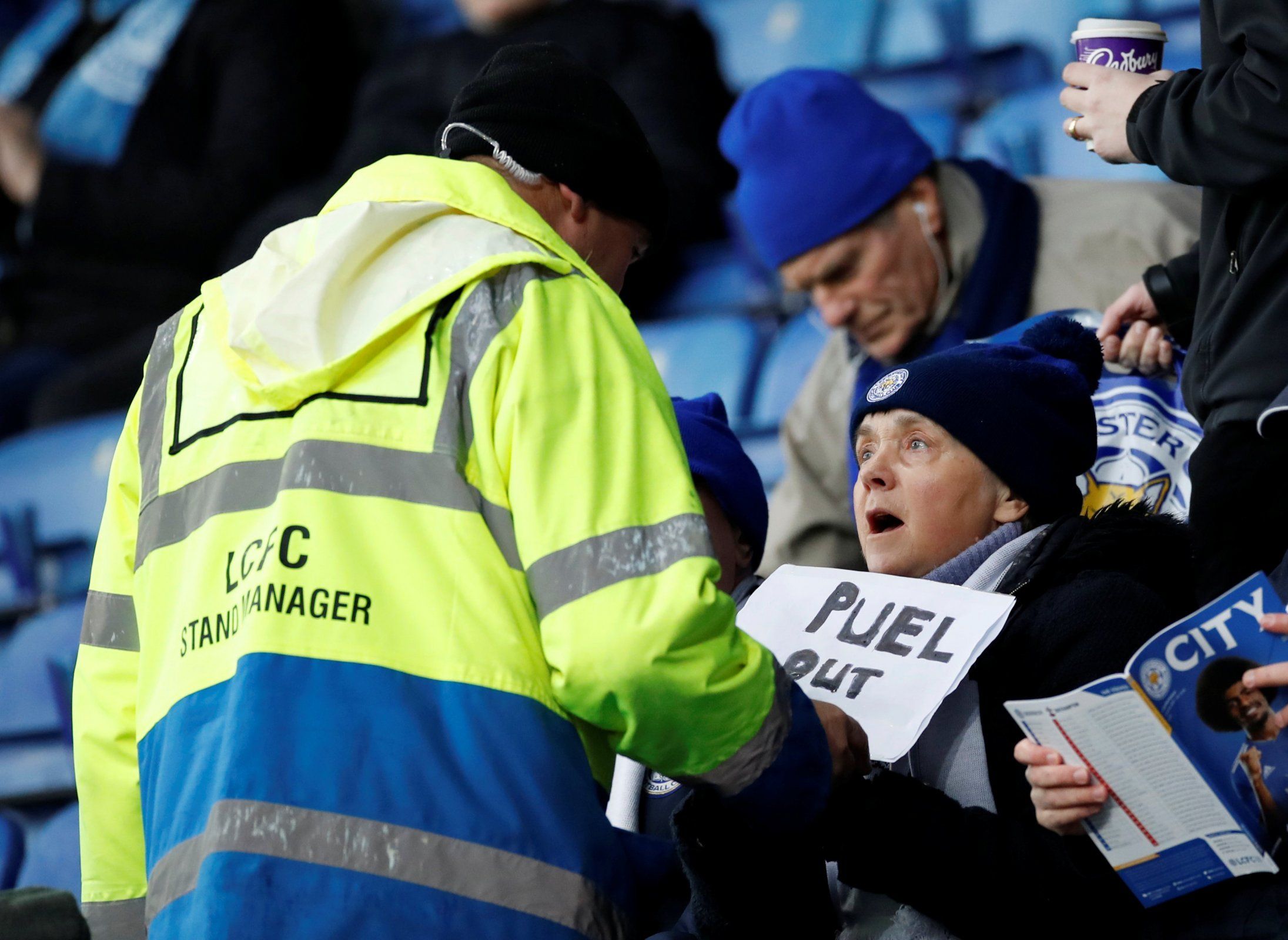 A Leicester City steward confiscates a sign saying 'Puel Out' from a fan before the Southampton match