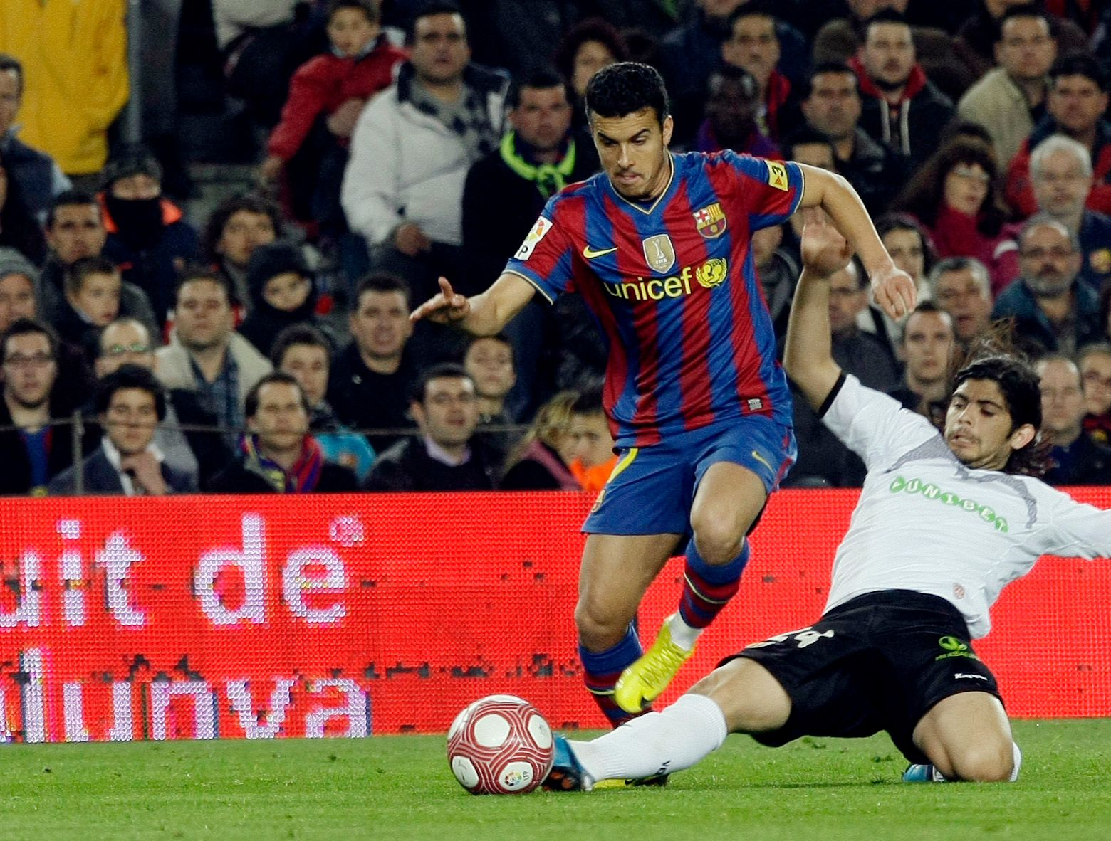 Barcelona's Pedro (L) is challenged by Valencia's Ever Banega during their Spanish first division soccer match at Nou Camp stadium in Barcelona March 14, 2010.   REUTERS/Gustau Nacarino  (SPAIN - Tags: SPORT SOCCER)