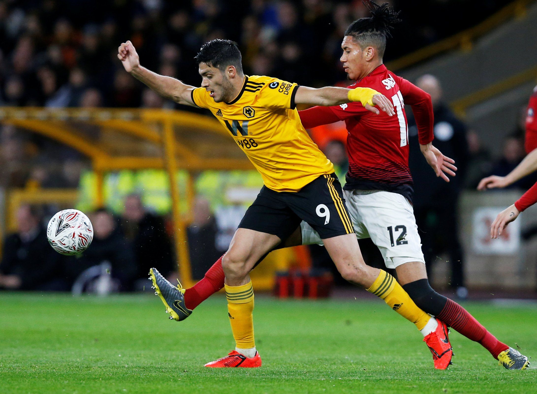 Raul Jimenez is challenged by Chris Smalling. 