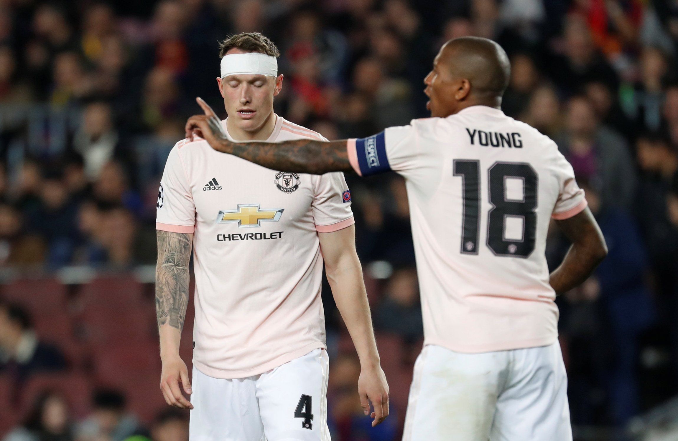 Man United defender Phil Jones looks dejected as Ashley Young points in Barcelona defeat