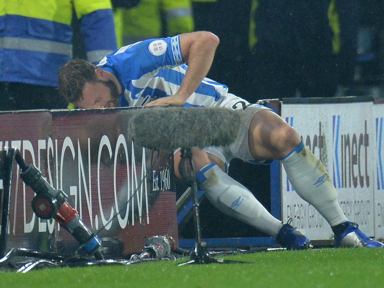 Soccer Football - Premier League - Huddersfield Town v Newcastle United - John Smith's Stadium, Huddersfield, Britain - December 15, 2018  Huddersfield Town's Laurent Depoitre falls into the advertising hoardings     REUTERS/Peter Powell  EDITORIAL USE ONLY. No use with unauthorized audio, video, data, fixture lists, club/league logos or 