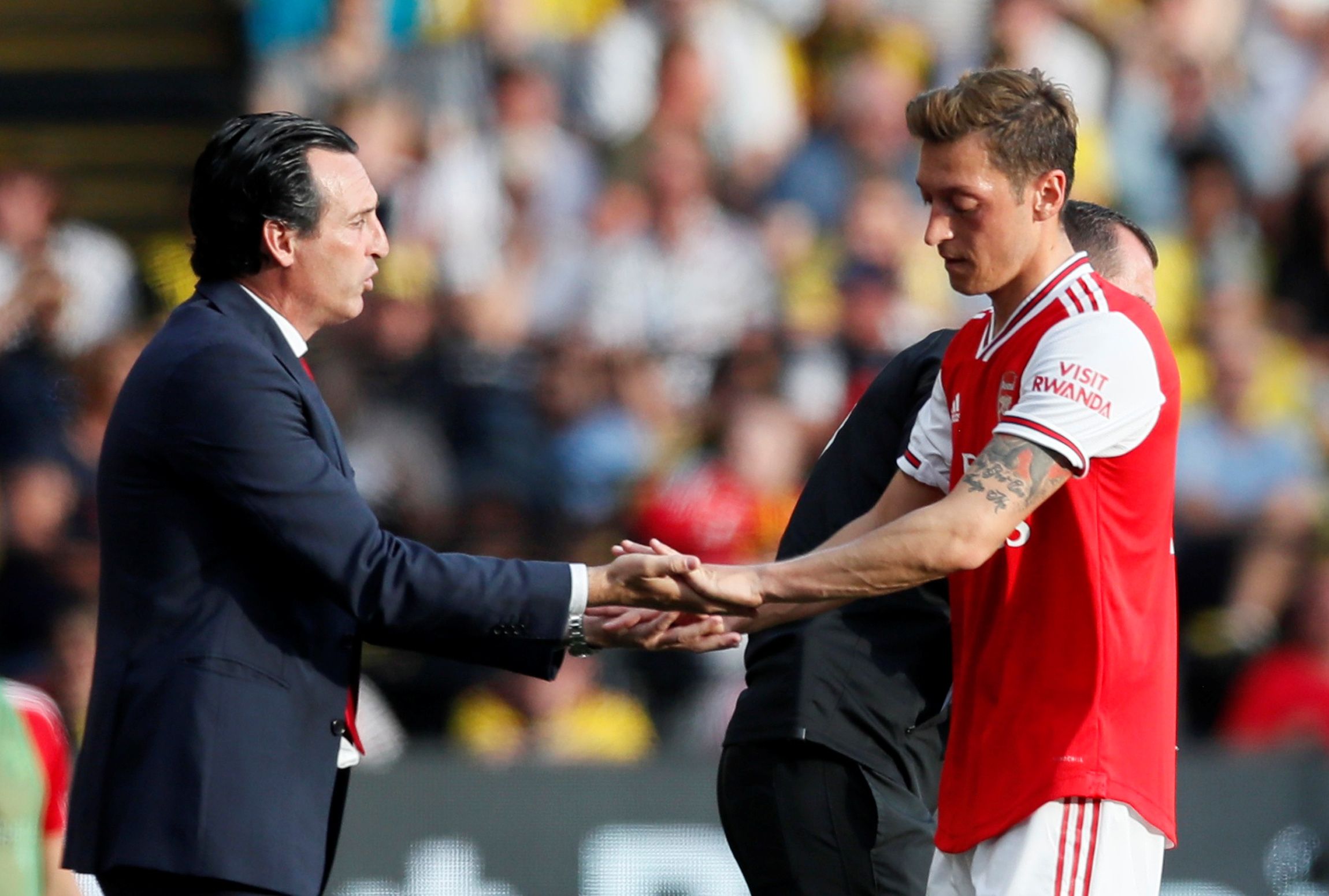 Soccer Football - Premier League - Watford v Arsenal - Vicarage Road, Watford, Britain - September 15, 2019  Arsenal's Mesut Ozil shakes hands with manager Unai Emery after being substituted off REUTERS/David Klein  EDITORIAL USE ONLY. No use with unauthorized audio, video, data, fixture lists, club/league logos or 