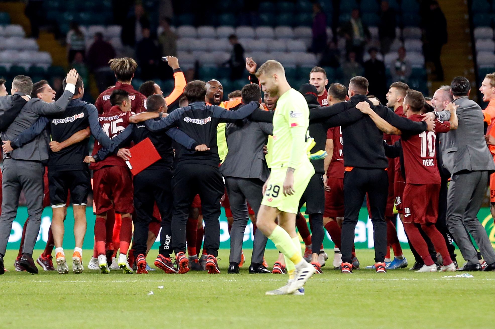Soccer Football - Champions League - Third Qualifying Round Second Leg - Celtic v CFR Cluj - Celtic Park, Glasgow, Britain - August 13, 2019   CFR Cluj players celebrate after the match as Celtic's Scott Bain looks dejected                   Action Images via Reuters/Carl Recine