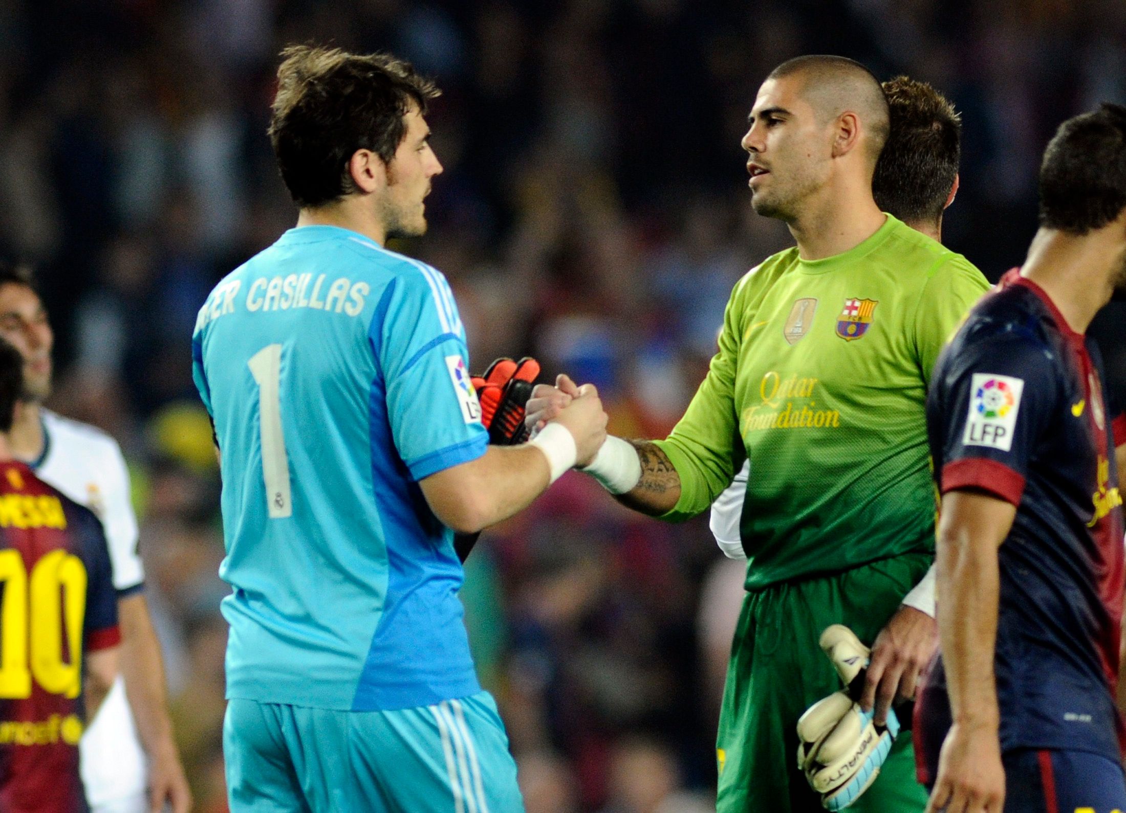 Real Madrid's goalkeeper Iker Casillas (L) greets Barcelona's goalkeeper Victor Valdes at the end of their Spanish first division soccer match at Nou Camp stadium in Barcelona, October 7, 2012.     REUTERS/Sergio Carmona (SPAIN - Tags: SPORT SOCCER)