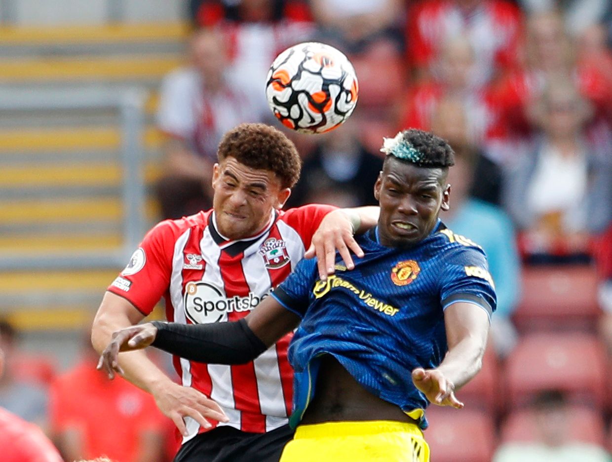 Soccer Football - Premier League - Southampton v Manchester United - St Mary's Stadium, Southampton, Britain - August 22, 2021  Manchester United's Paul Pogba in action with Southampton's Che Adams REUTERS/Peter Nicholls EDITORIAL USE ONLY. No use with unauthorized audio, video, data, fixture lists, club/league logos or 'live' services. Online in-match use limited to 75 images, no video emulation. No use in betting, games or single club /league/player publications.  Please contact your account r