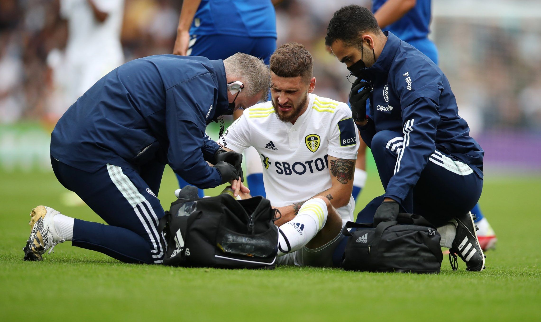 Leeds United midfielder Mateusz Klich receives treatment during Premier League clash vs Everton