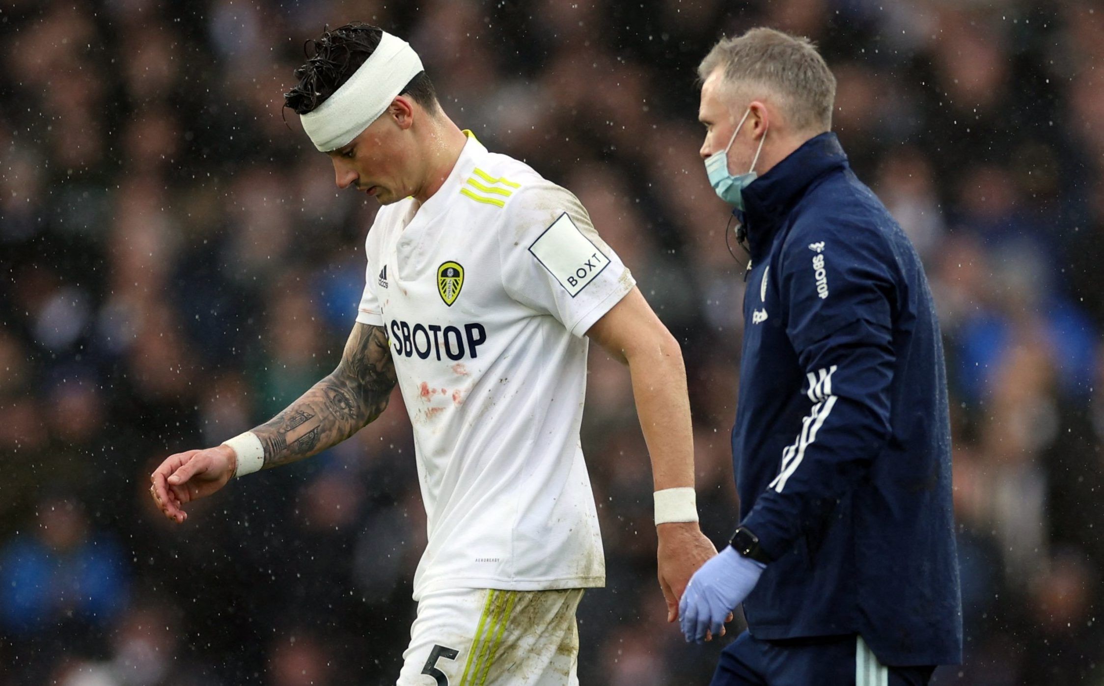 Leeds United defender Robin Koch leaves the pitch at Elland Road after receiving head treatment against Manchester United