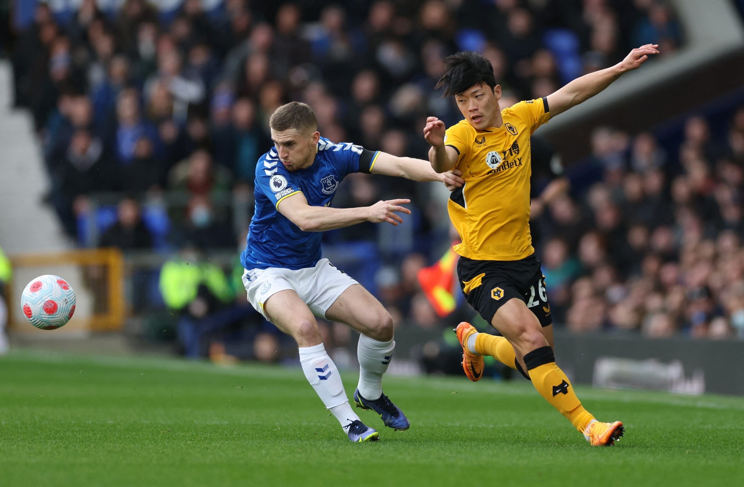 Soccer Football - Premier League - Everton v Wolverhampton Wanderers - Goodison Park, Liverpool, Britain - March 13, 2022 Everton's Jonjoe Kenny in action with Wolverhampton Wanderers' Hwang Hee-Chan Action Images via Reuters/Carl Recine EDITORIAL USE ONLY. No use with unauthorized audio, video, data, fixture lists, club/league logos or 'live' services. Online in-match use limited to 75 images, no video emulation. No use in betting, games or single club /league/player publications.  Please conta