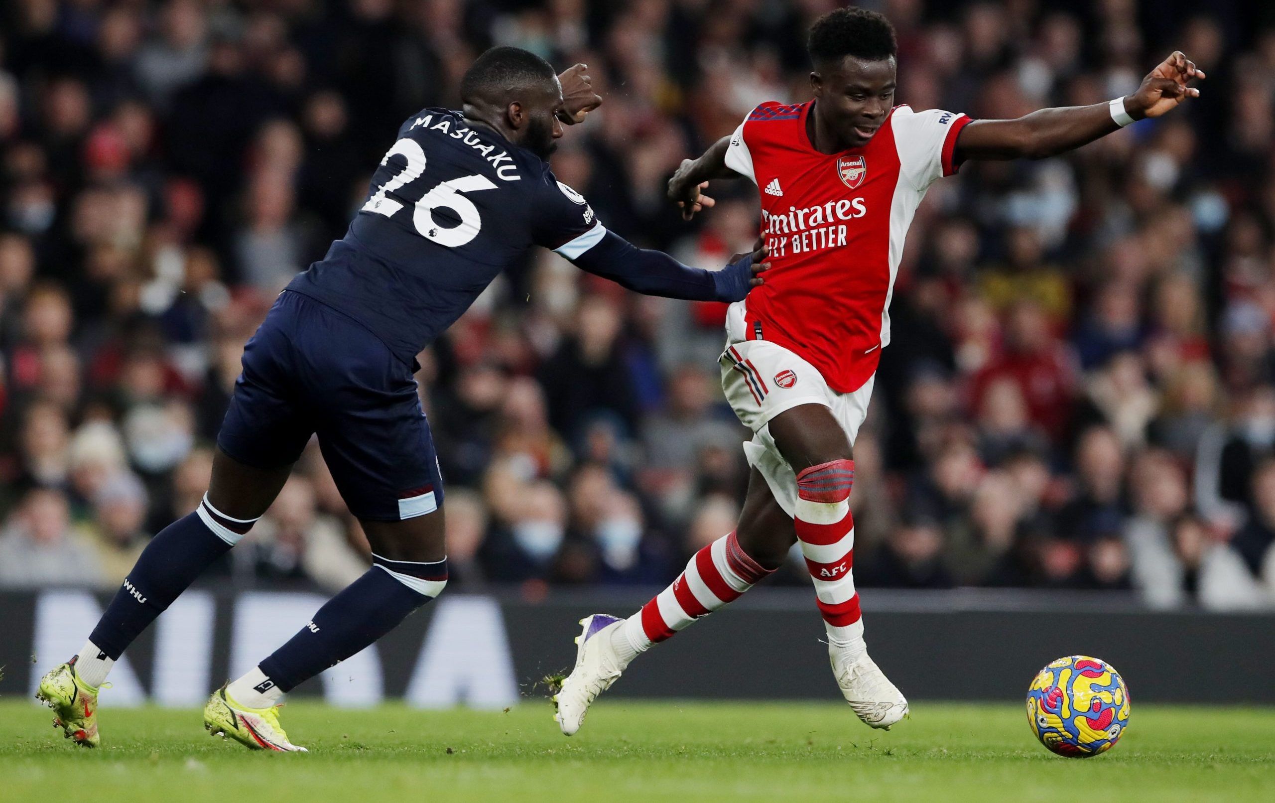 Soccer Football - Premier League - Arsenal v West Ham United - Emirates Stadium, London, Britain - December 15, 2021 Arsenal's Bukayo Saka in action with West Ham United's Arthur Masuaku Action Images via Reuters/Andrew Couldridge EDITORIAL USE ONLY. No use with unauthorized audio, video, data, fixture lists, club/league logos or 'live' services. Online in-match use limited to 75 images, no video emulation. No use in betting, games or single club /league/player publications.  Please contact your
