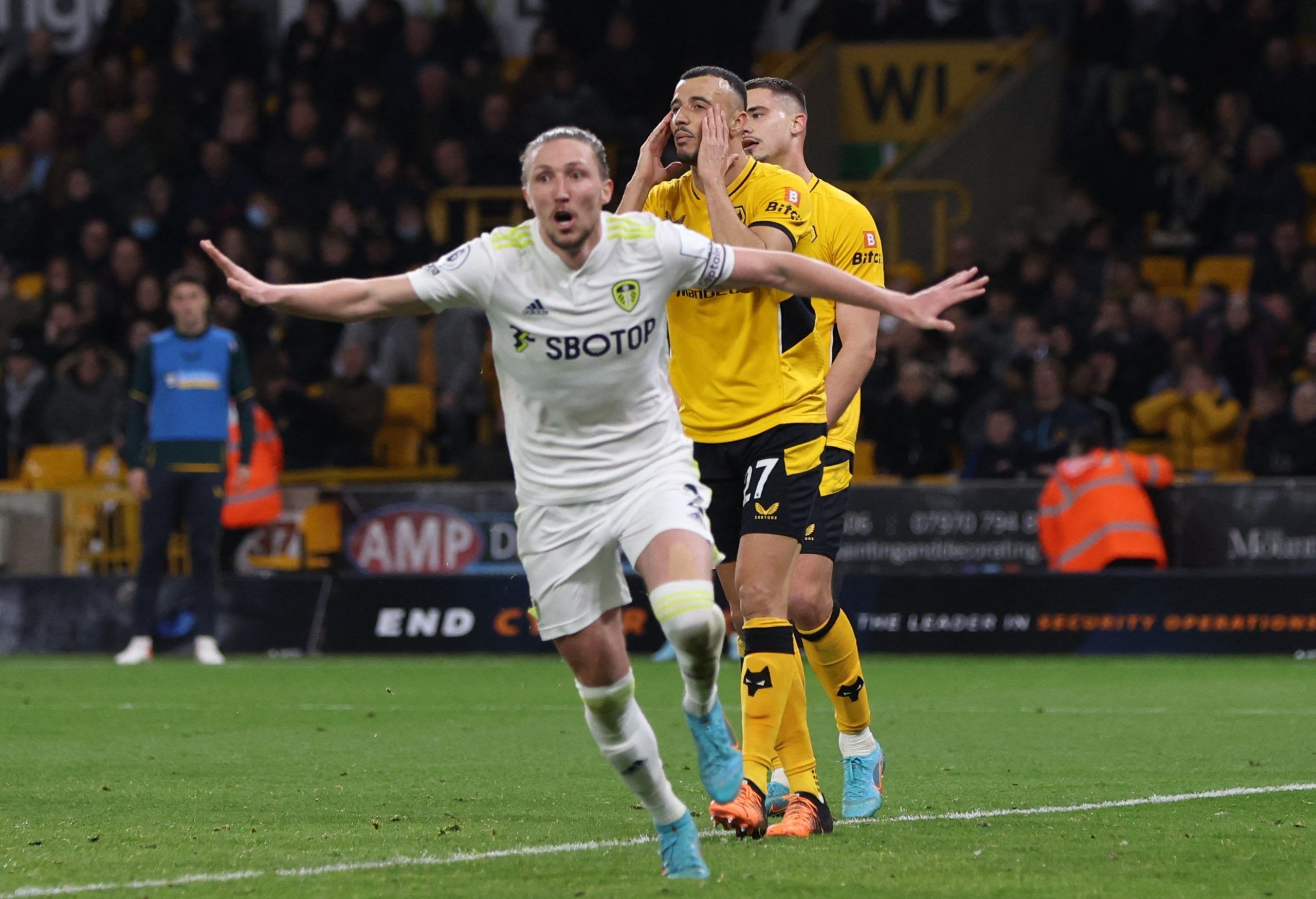 Soccer Football - Premier League - Wolverhampton Wanderers v Leeds United - Molineux Stadium, Wolverhampton, Britain - March 18, 2022 Wolverhampton Wanderers' Romain Saiss looks dejected as Leeds United's Luke Ayling celebrates scoring their third goal Action Images via Reuters/Paul Childs EDITORIAL USE ONLY. No use with unauthorized audio, video, data, fixture lists, club/league logos or 'live' services. Online in-match use limited to 75 images, no video emulation. No use in betting, games or s