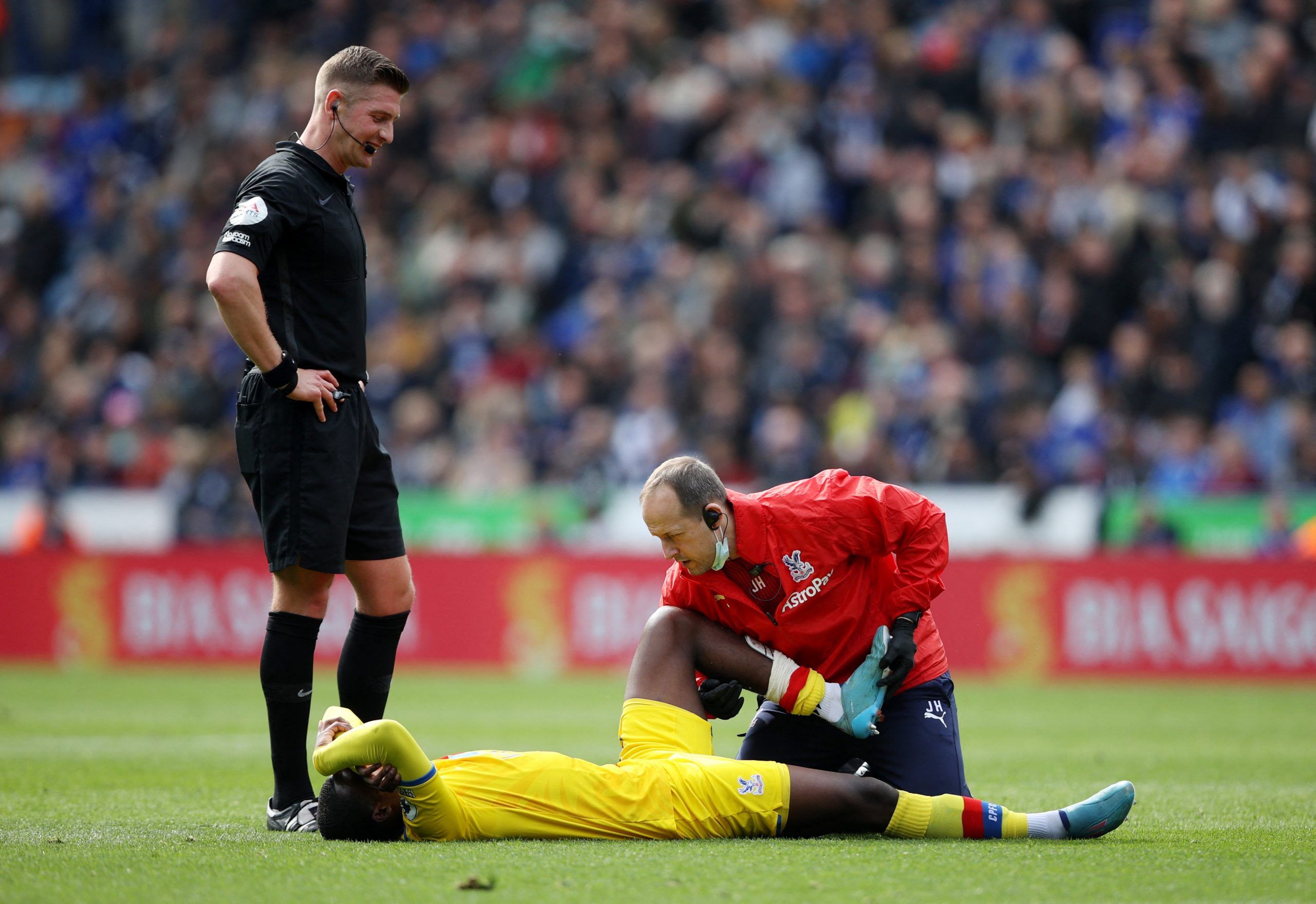 Soccer Football - Premier League - Leicester City v Crystal Palace - King Power Stadium, Leicester, Britain - April 10, 2022 Crystal Palace's Tyrick Mitchell receives medical attention after sustaining an injury as referee Robert Jones looks on Action Images via Reuters/Molly Darlington EDITORIAL USE ONLY. No use with unauthorized audio, video, data, fixture lists, club/league logos or 'live' services. Online in-match use limited to 75 images, no video emulation. No use in betting, games or sing