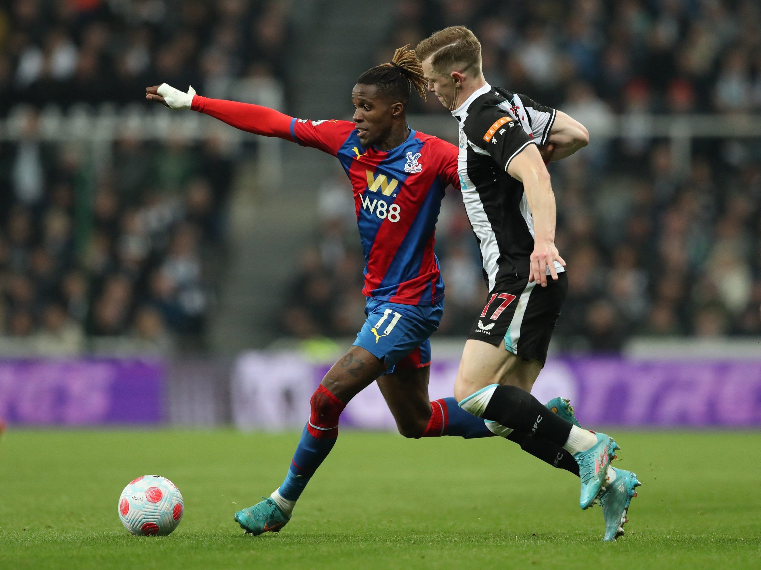 Newcastle United's Emil Krafth in action with Crystal Palace's Wilfried Zaha Soccer Football - Premier League - Newcastle United v Crystal Palace - St James' Park, Newcastle, Britain - April 20, 2022  Newcastle United's Emil Krafth in action with Crystal Palace's Wilfried Zaha REUTERS/Scott Heppell EDITORIAL USE ONLY. No use with unauthorized audio, video, data, fixture lists, club/league logos or 'live' services. Online in-match use limited to 75 images, no video emulation. No use in betting, g