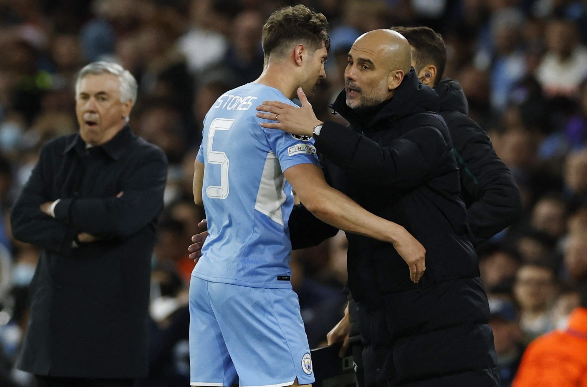 Soccer Football - Champions League - Semi Final - First Leg - Manchester City v Real Madrid - Etihad Stadium, Manchester, Britain - April 26, 2022 Manchester City manager Pep Guardiola with John Stones who comes off as a substitute Action Images via Reuters/Jason Cairnduff