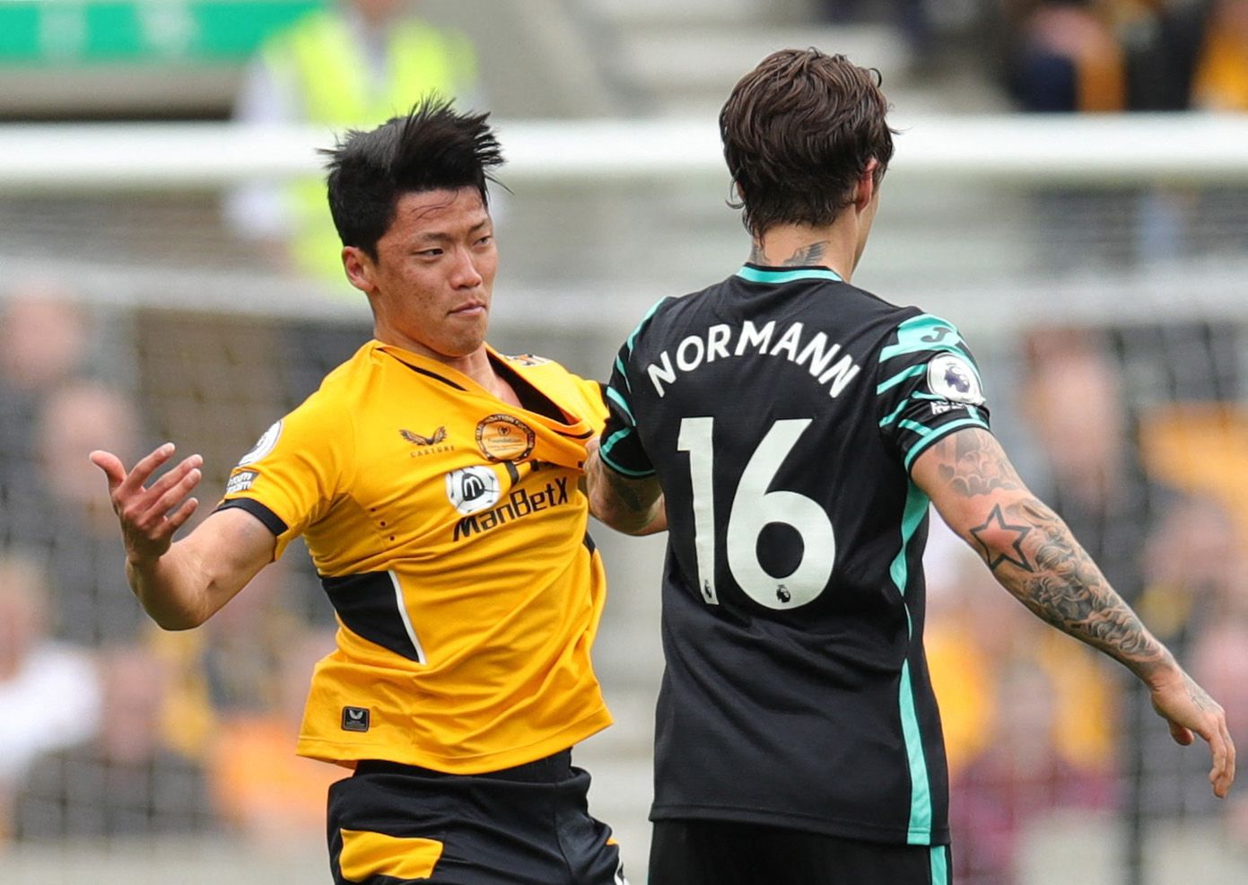 Soccer Football - Premier League - Wolverhampton Wanderers v Norwich City - Molineux Stadium, Wolverhampton, Britain - May 15, 2022 Wolverhampton Wanderers' Hwang Hee-Chan clashes with Norwich City's Mathias Normann REUTERS/Chris Radburn EDITORIAL USE ONLY. No use with unauthorized audio, video, data, fixture lists, club/league logos or 'live' services. Online in-match use limited to 75 images, no video emulation. No use in betting, games or single club /league/player publications.  Please conta