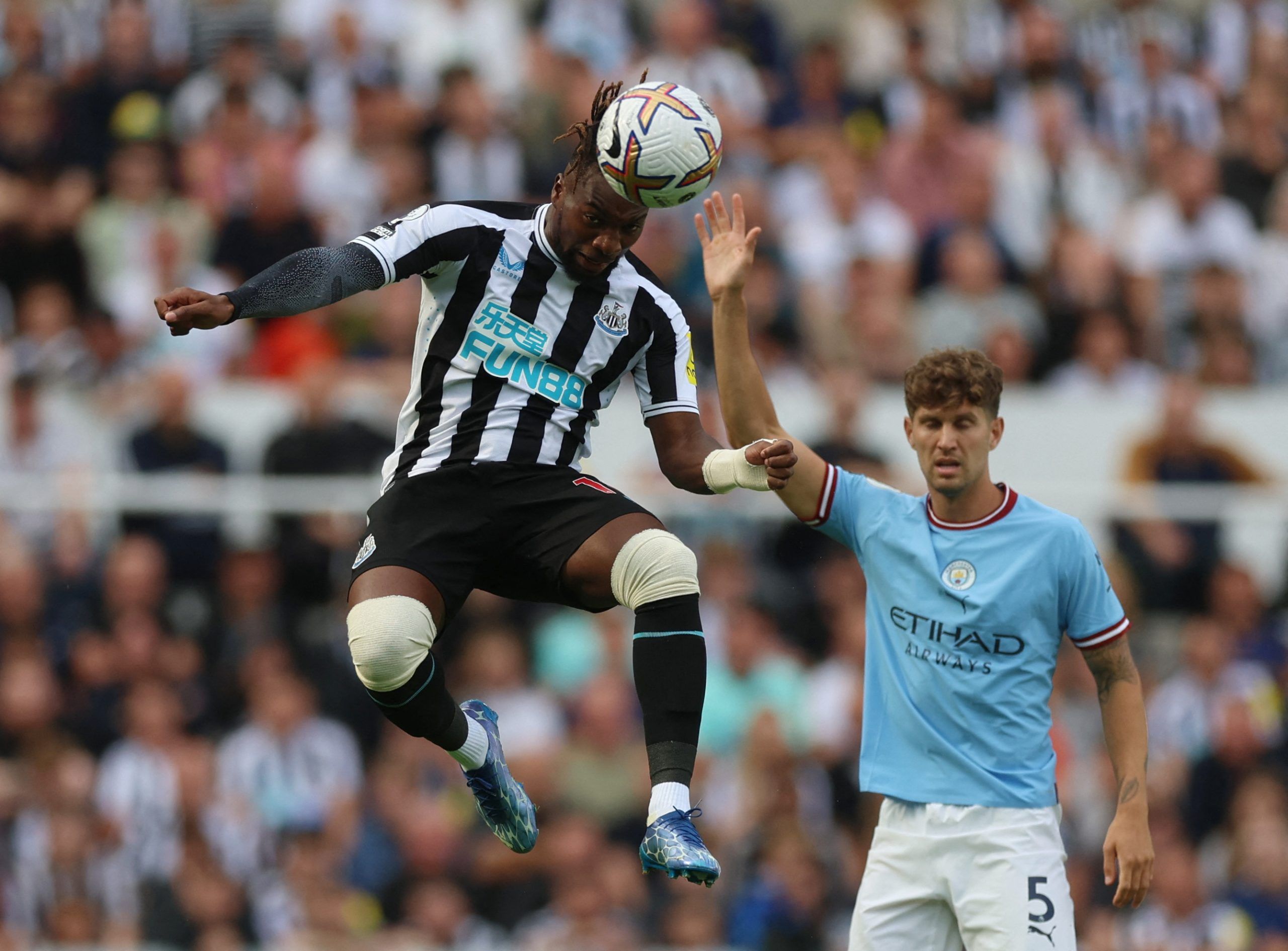 Soccer Football - Premier League - Newcastle United v Manchester City - St James' Park, Newcastle, Britain - August 21, 2022 Newcastle United's Allan Saint-Maximin in action with Manchester City's John Stones Action Images via Reuters/Lee Smith EDITORIAL USE ONLY. No use with unauthorized audio, video, data, fixture lists, club/league logos or 'live' services. Online in-match use limited to 75 images, no video emulation. No use in betting, games or single club /league/player publications.  Pleas