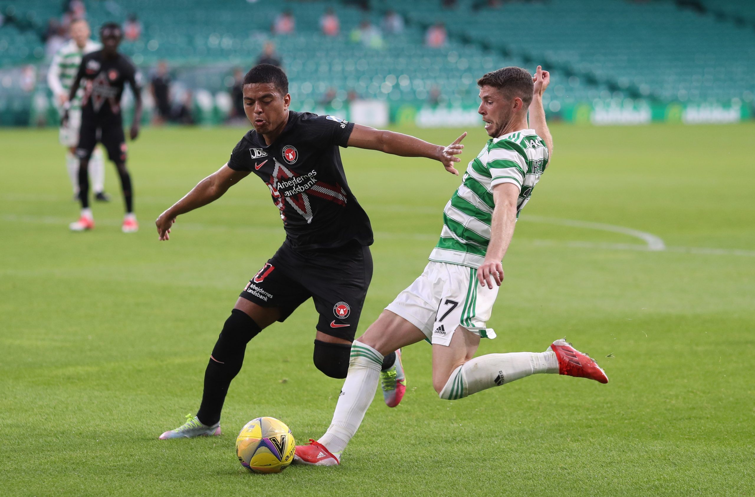 Soccer Football - Champions League - Second Qualifying Round - Celtic v FC Midtjylland - Celtic Park, Glasgow, Scotland, Britain - July 20, 2021  Celtic's Ryan Christie in action with FC Midtjylland's Evander REUTERS/Russell Cheyne