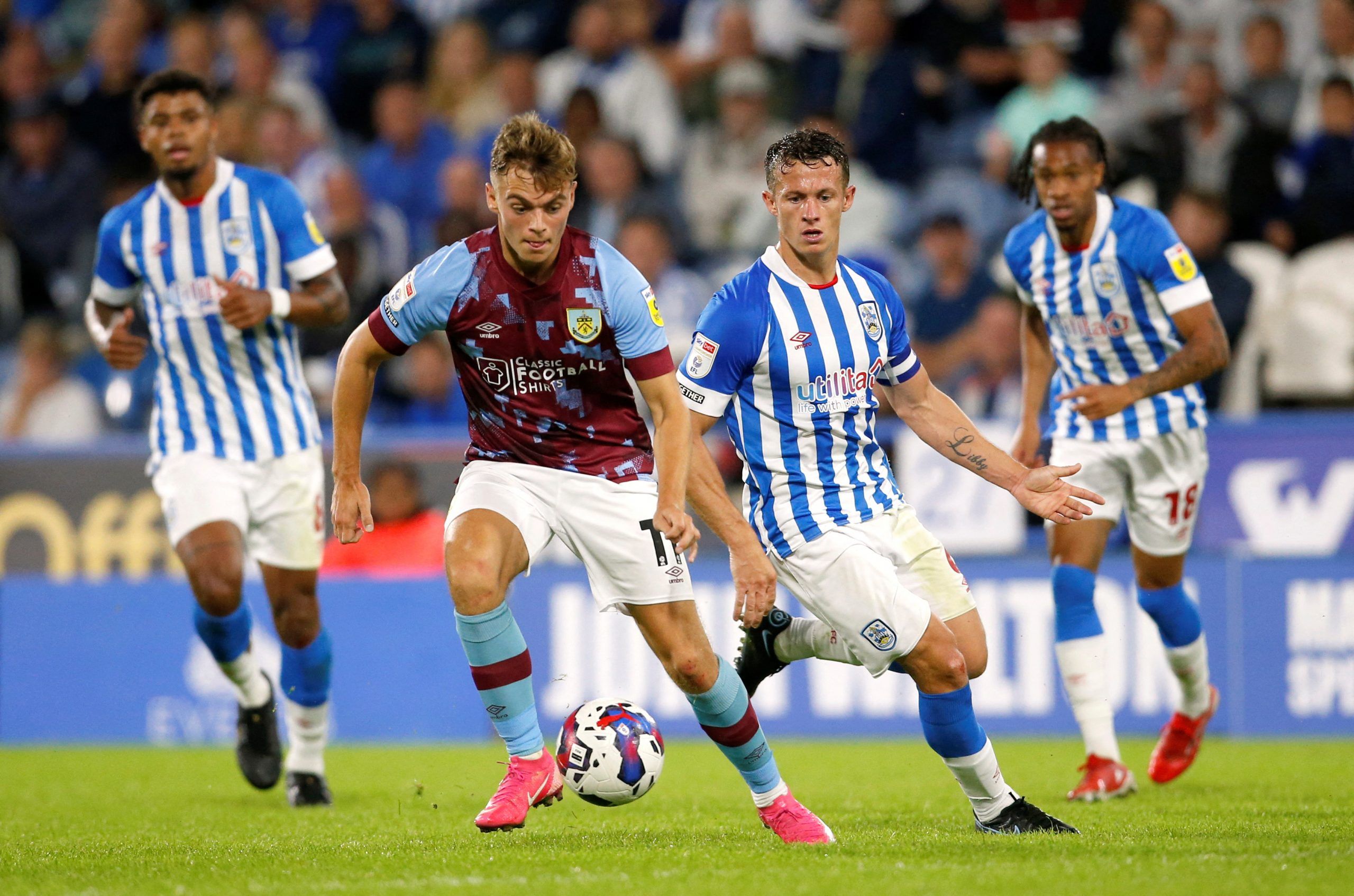 Soccer Football - Championship - Huddersfield Town v Burnley - John Smith's Stadium, Huddersfield, Britain - July 29, 2022 Burnley's Scott Twine in action with Huddersfield Town's Jonathan Hogg   Action Images/Ed Sykes  EDITORIAL USE ONLY. No use with unauthorized audio, video, data, fixture lists, club/league logos or 