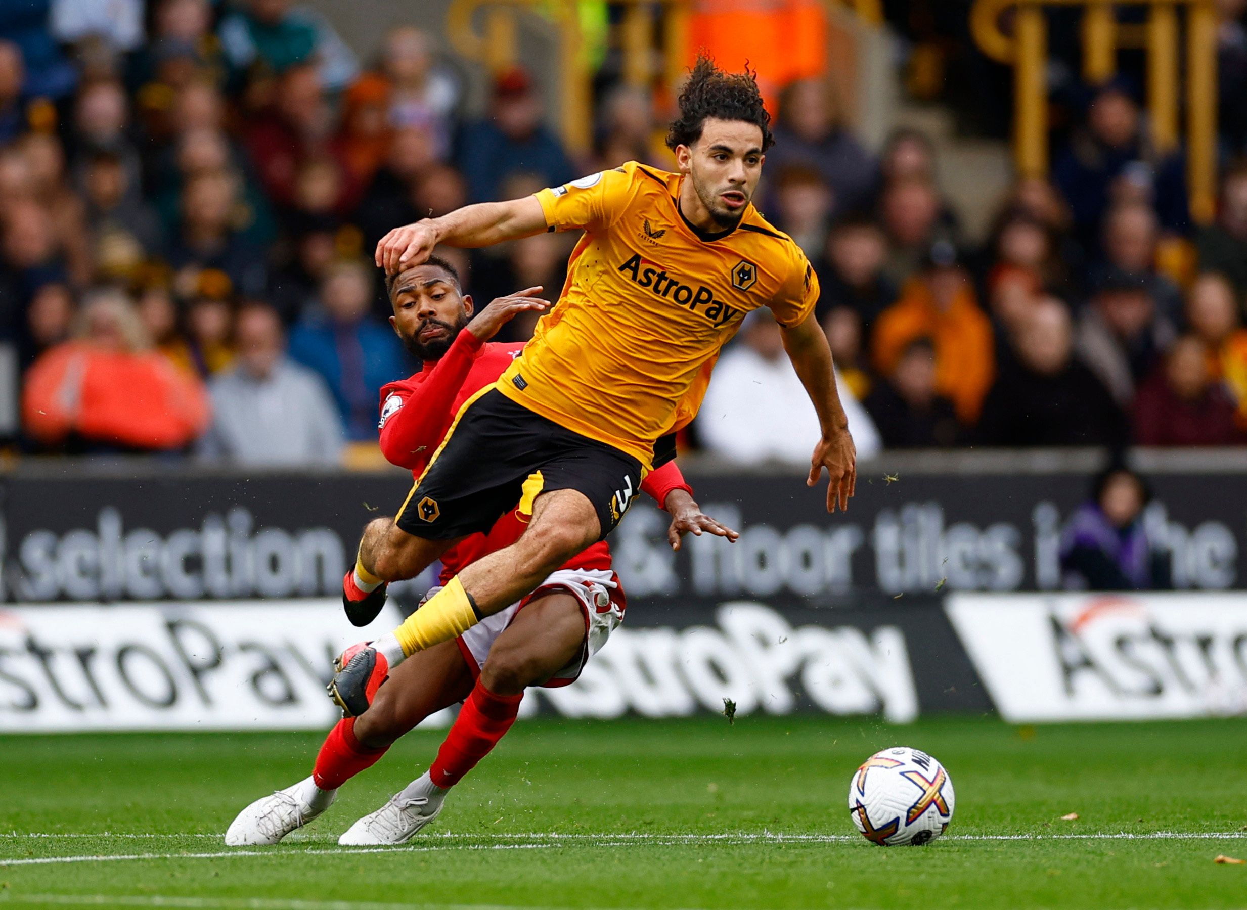 Soccer Football - Premier League - Wolverhampton Wanderers v Nottingham Forest - Molineux Stadium, Wolverhampton, Britain - October 15, 2022  Nottingham Forest's Emmanuel Dennis fouls Wolverhampton Wanderers' Rayan Ait-Nouri before receiving a yellow card Action Images via Reuters/Andrew Boyers EDITORIAL USE ONLY. No use with unauthorized audio, video, data, fixture lists, club/league logos or 'live' services. Online in-match use limited to 75 images, no video emulation. No use in betting, games