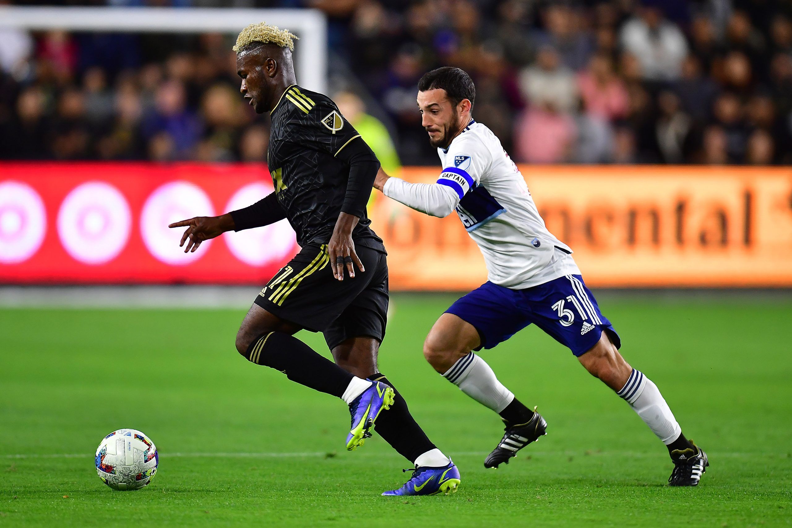Mar 20, 2022; Los Angeles, California, USA; Los Angeles FC midfielder José Cifuentes (11) moves the ball ahead of Vancouver Whitecaps midfielder Russell Teibert (31) during the first half at Banc of California Stadium. Mandatory Credit: Gary A. Vasquez-USA TODAY Sports