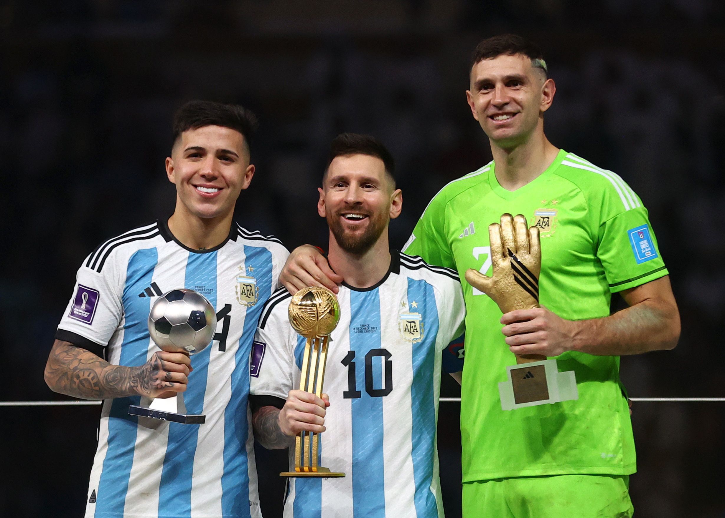 Soccer Football - FIFA World Cup Qatar 2022 - Final - Argentina v France - Lusail Stadium, Lusail, Qatar - December 18, 2022 Best Young Player winner Argentina's Enzo Fernandez, Golden Ball winner Argentina's Lionel Messi and Golden Glove winner Argentina's Emiliano Martinez pose with the trophies REUTERS/Carl Recine