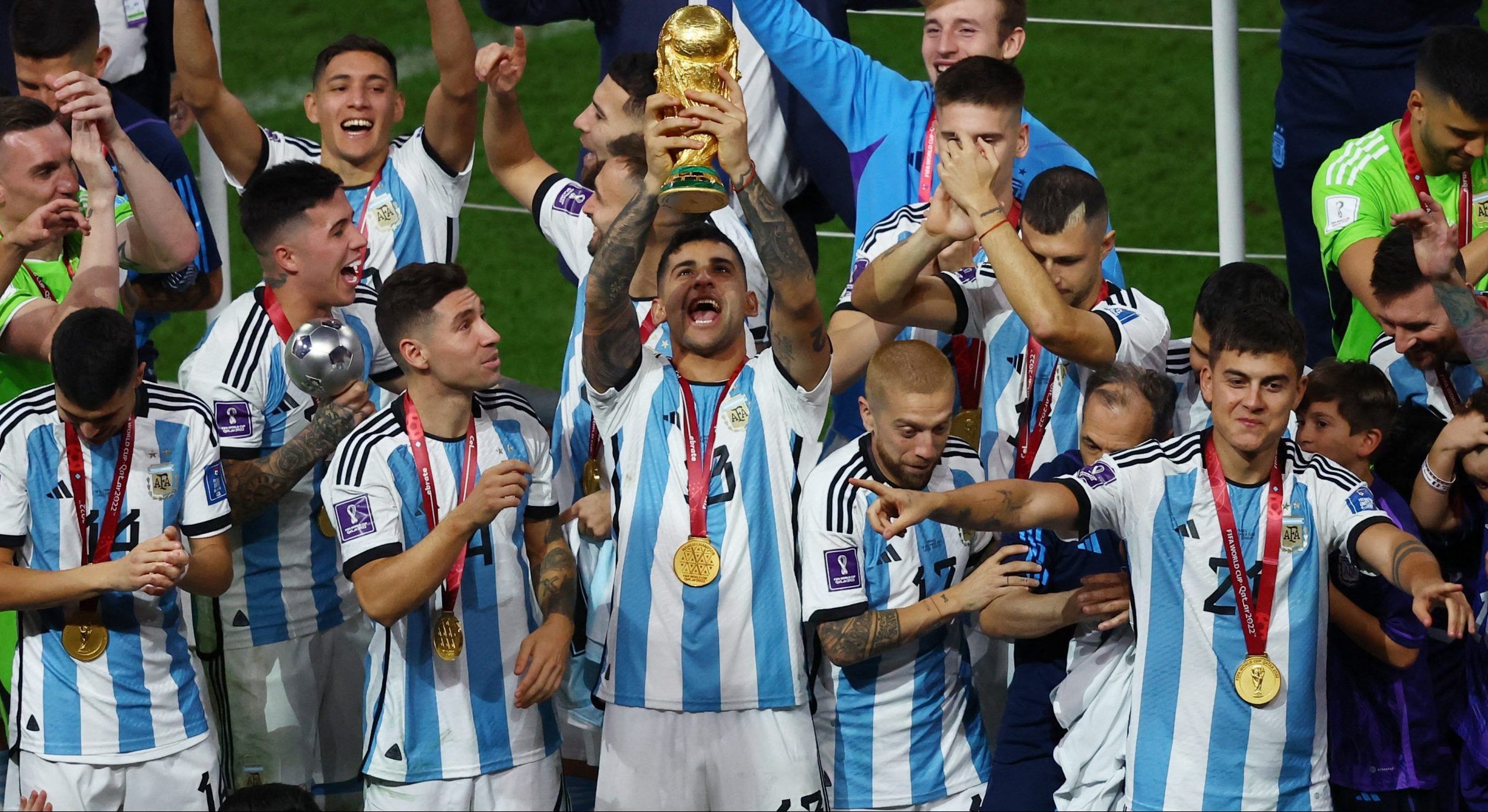 Soccer Football - FIFA World Cup Qatar 2022 - Final - Argentina v France - Lusail Stadium, Lusail, Qatar - December 18, 2022 Argentina's Cristian Romero celebrates with the trophy after winning the World Cup with teammates REUTERS/Paul Childs