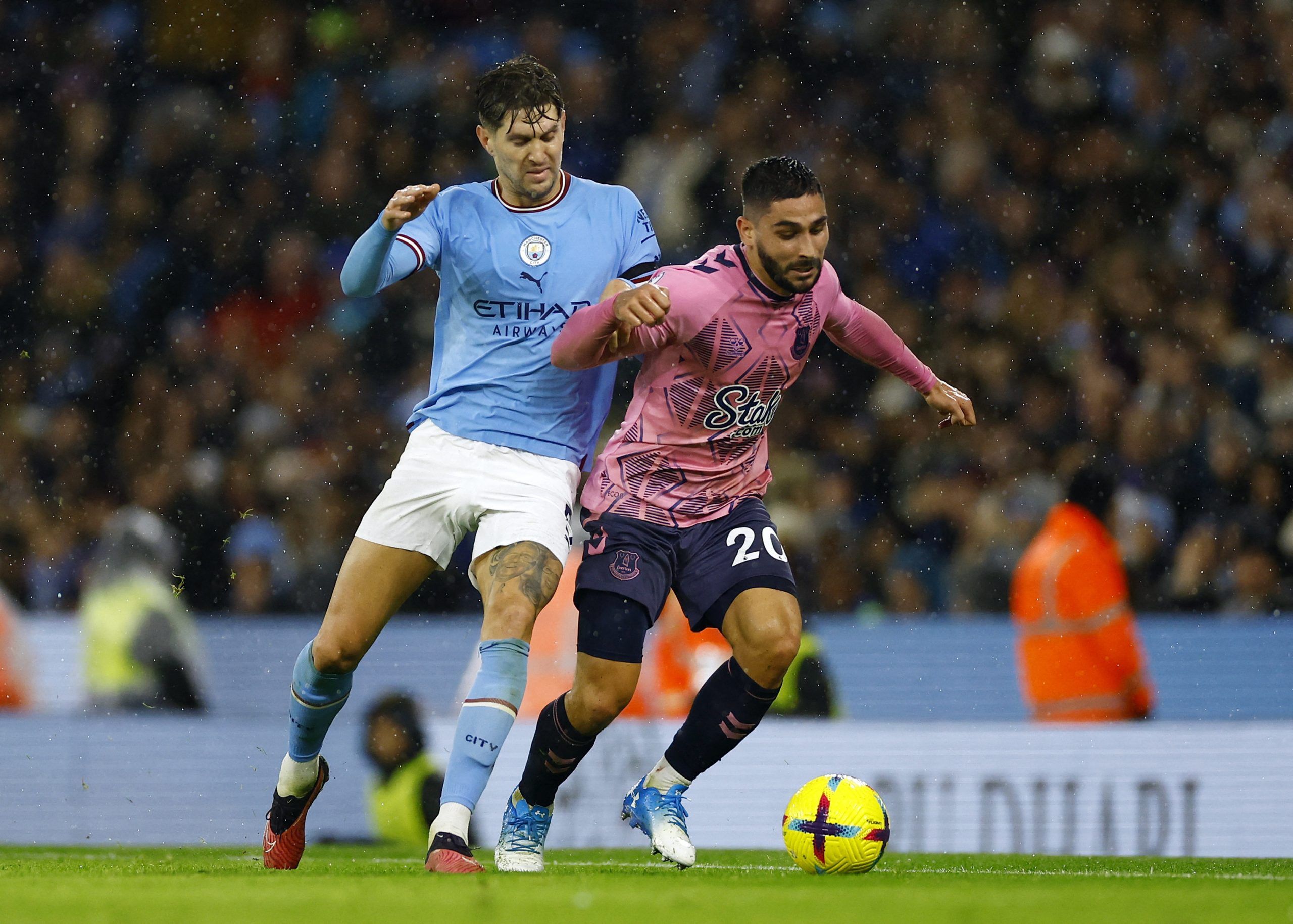 Soccer Football - Premier League - Manchester City v Everton - Etihad Stadium, Manchester, Britain - December 31, 2022 Everton's Neal Maupay in action with Manchester City's John Stones Action Images via Reuters/Andrew Boyers EDITORIAL USE ONLY. No use with unauthorized audio, video, data, fixture lists, club/league logos or 'live' services. Online in-match use limited to 75 images, no video emulation. No use in betting, games or single club /league/player publications.  Please contact your acco