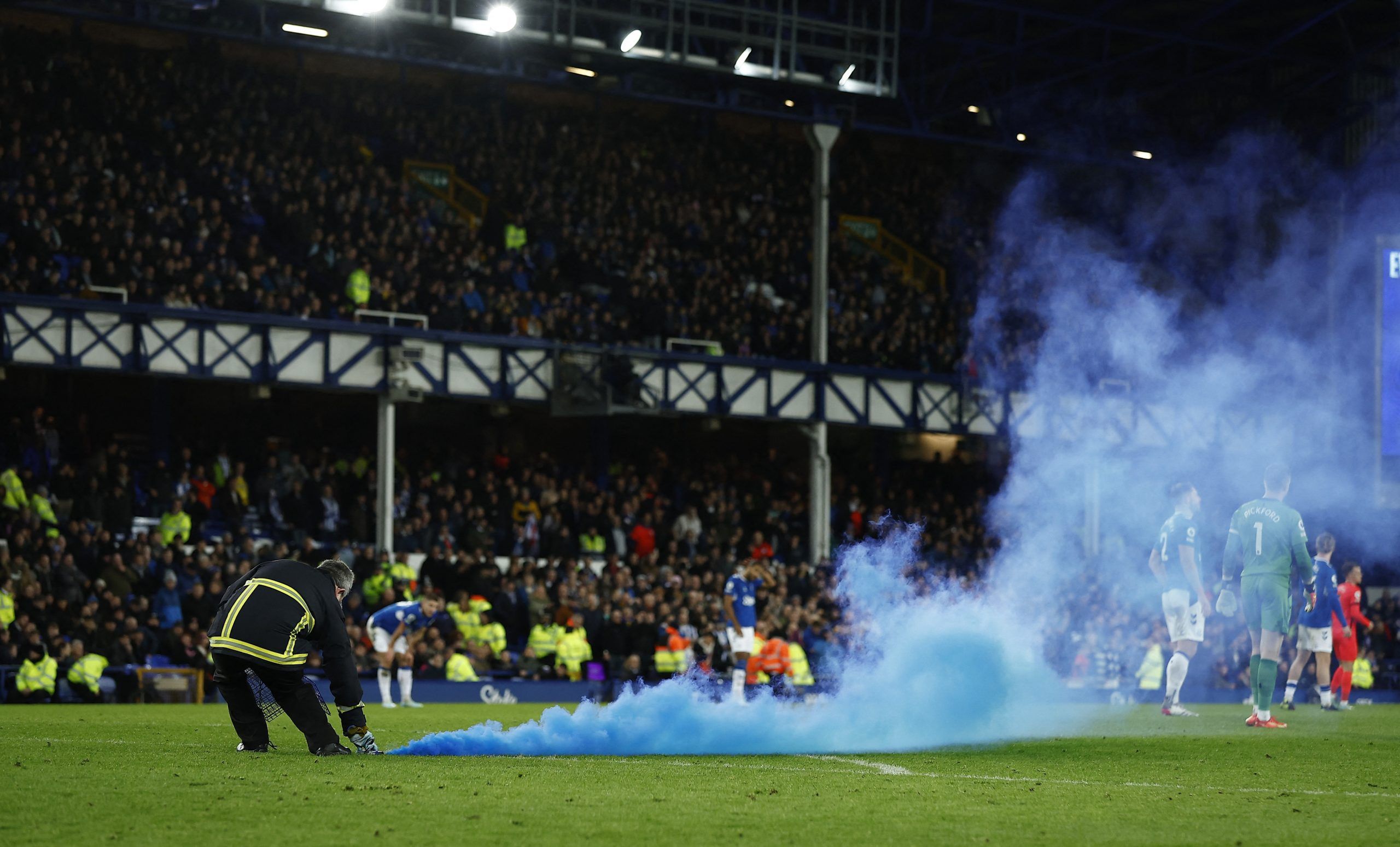 Soccer Football - Premier League - Everton v Brighton &amp; Hove Albion - Goodison Park, Liverpool, Britain - January 3, 2023 Stewards remove flares from the pitch Action Images via Reuters/Jason Cairnduff EDITORIAL USE ONLY. No use with unauthorized audio, video, data, fixture lists, club/league logos or 'live' services. Online in-match use limited to 75 images, no video emulation. No use in betting, games or single club /league/player publications.  Please contact your account representative f