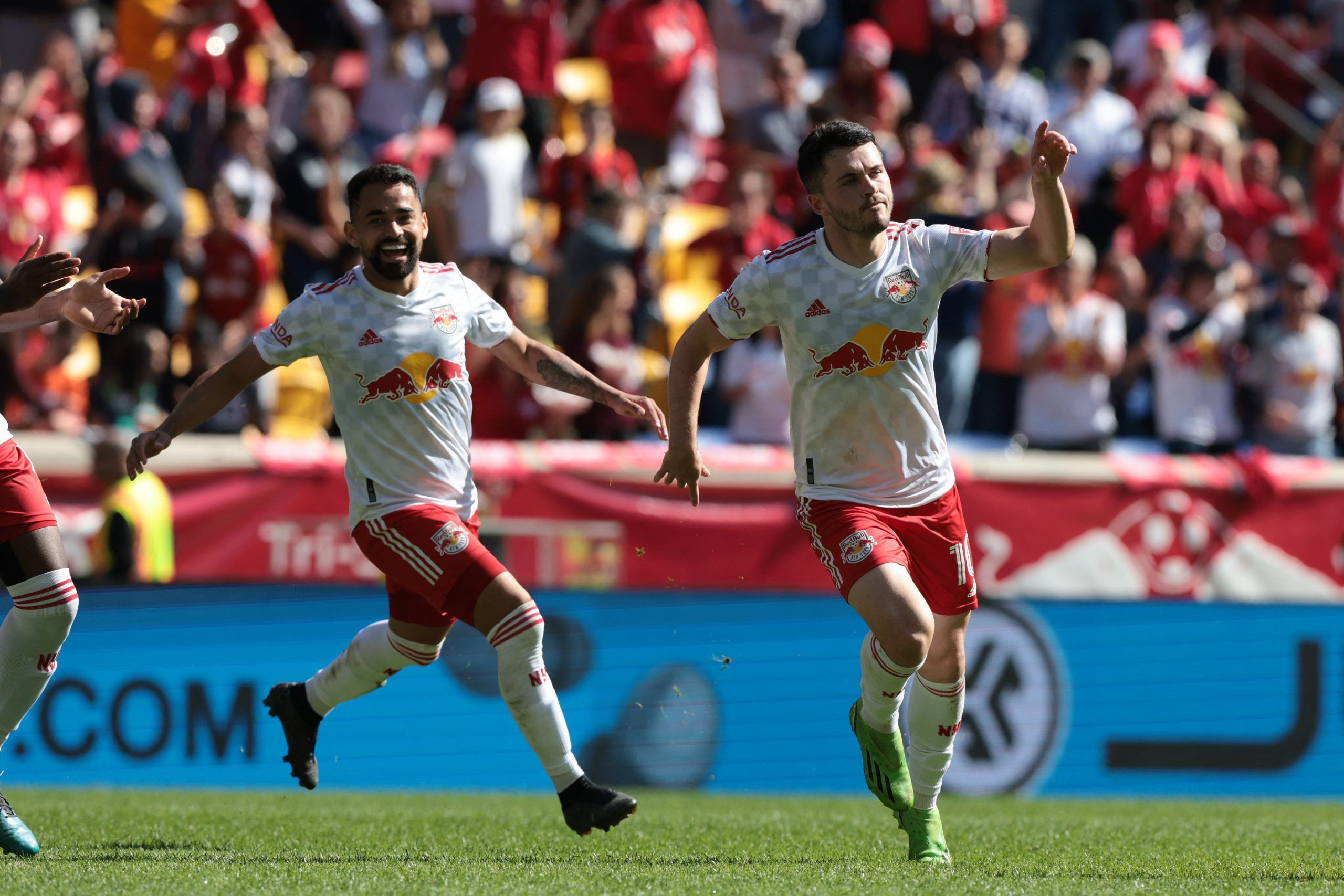 Oct 15, 2022; Harrison, New Jersey, USA; New York Red Bulls midfielder Lewis Morgan (10) celebrates with midfielder Luquinhas (82) after scoring a goal against FC Cincinnati during the second half at Red Bull Arena. Mandatory Credit: Vincent Carchietta-USA TODAY Sports