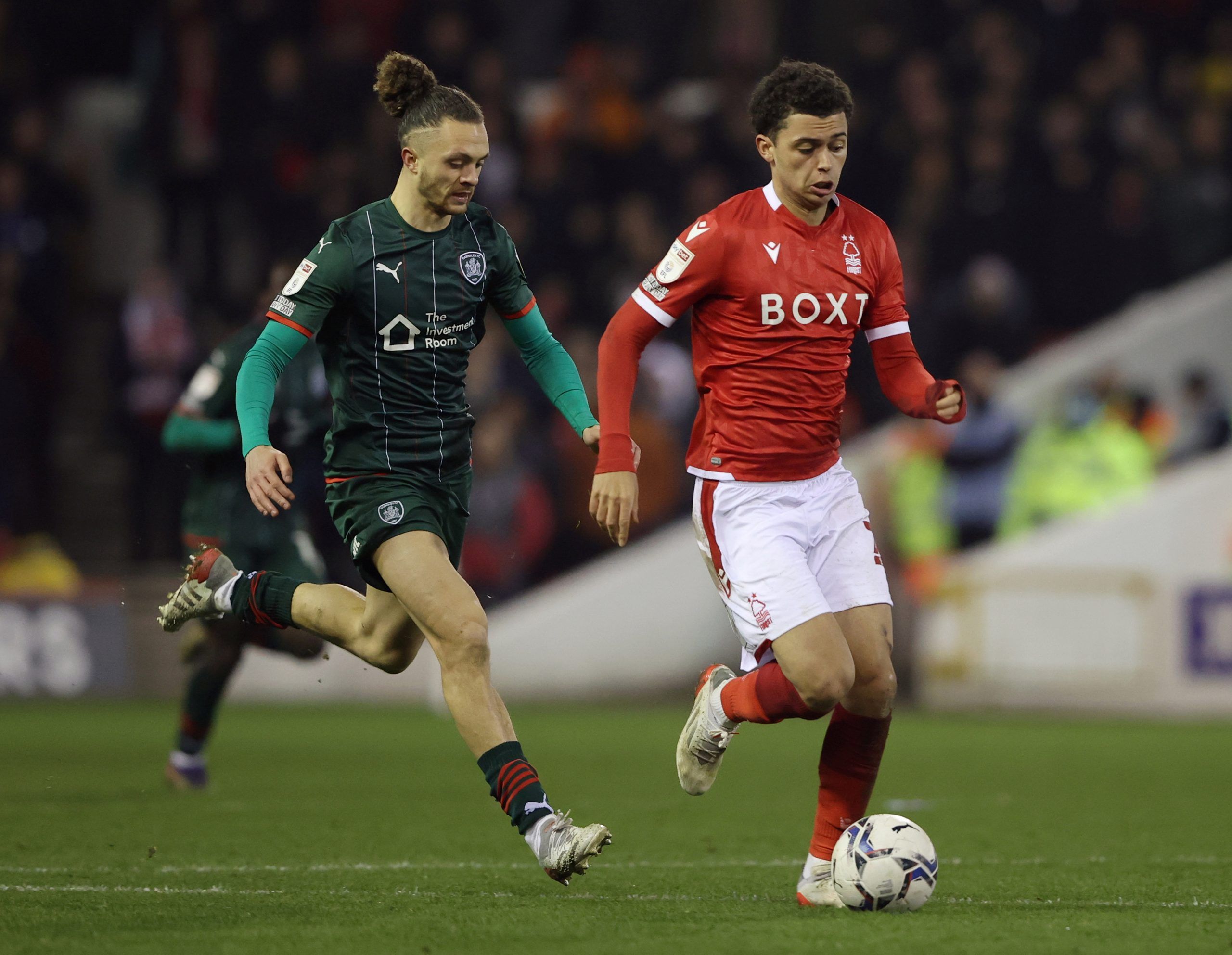 Soccer Football - Championship -  Nottingham Forest v Barnsley - City Ground, Nottingham, Britain - January 25, 2022  Barnsley's Jordan Williams in action with Nottingham Forest's Brennan Johnson   Action Images/Molly Darlington    EDITORIAL USE ONLY. No use with unauthorized audio, video, data, fixture lists, club/league logos or 