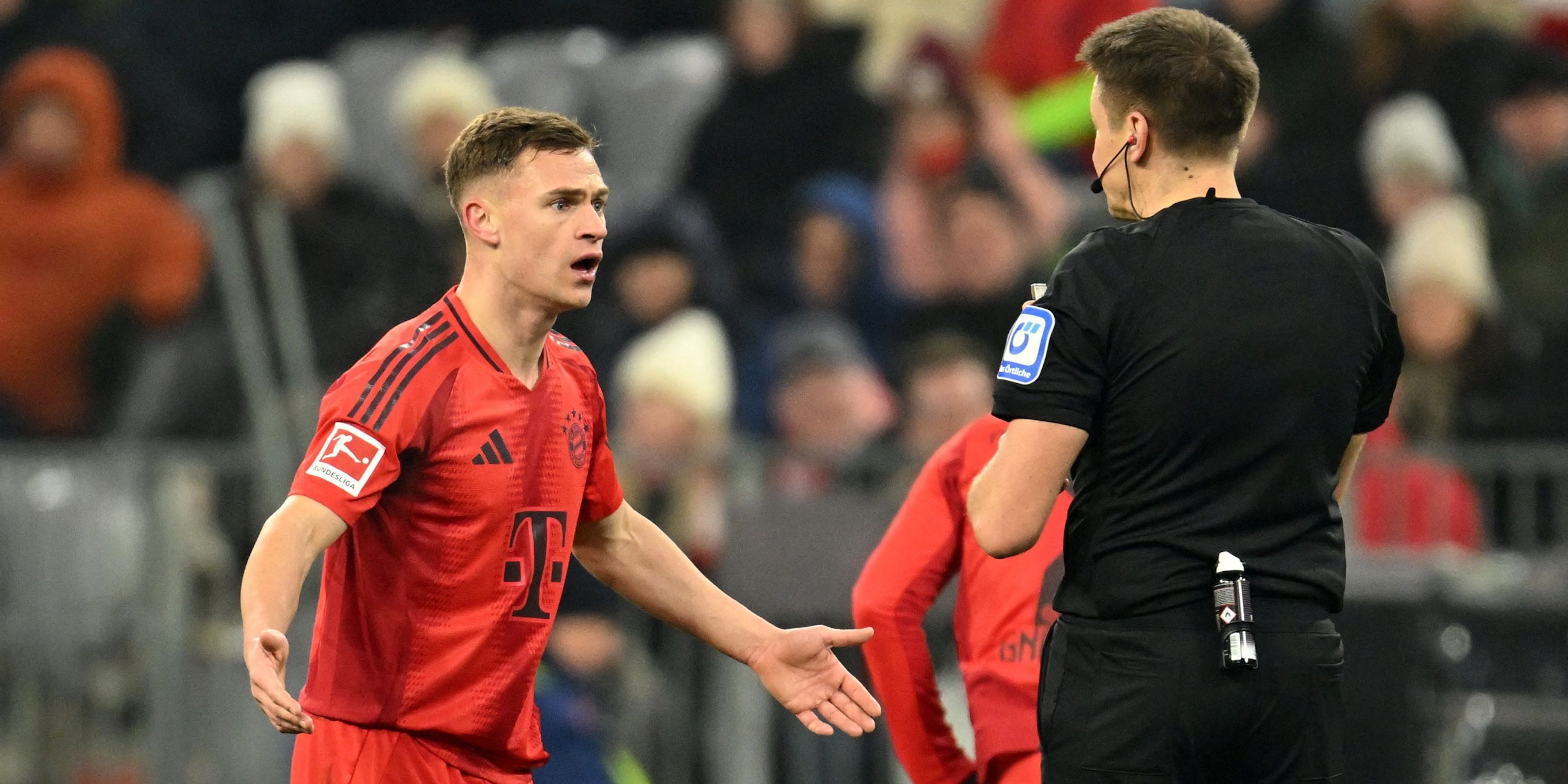 Joshua Kimmich of Bayern Munich reacts in front of referee Tobias Reichel