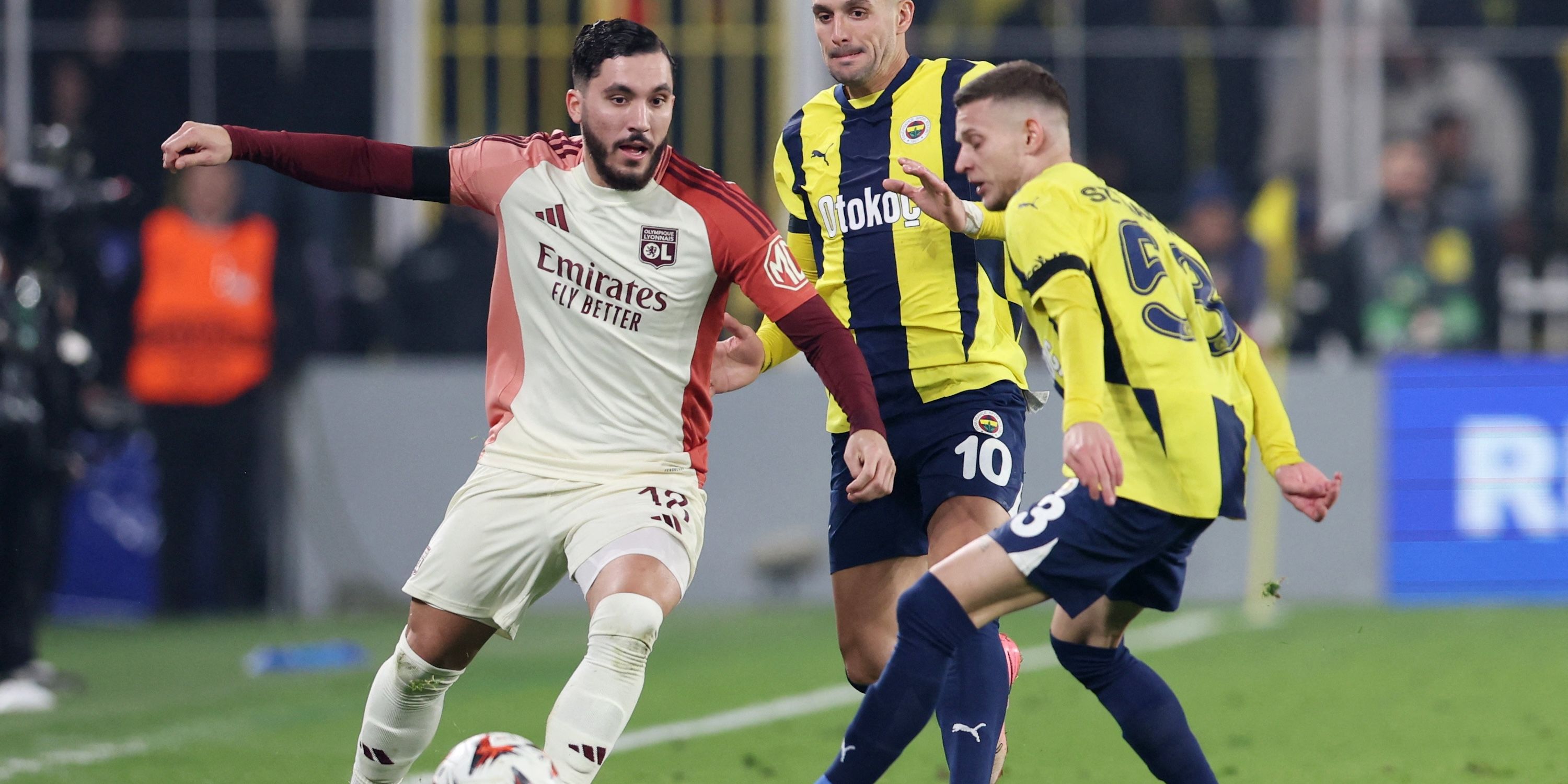 Olympique Lyonnais' Rayan Cherki in action with Fenerbahce's Dusan Tadic and Fenerbahce's Sebastian Szymanski