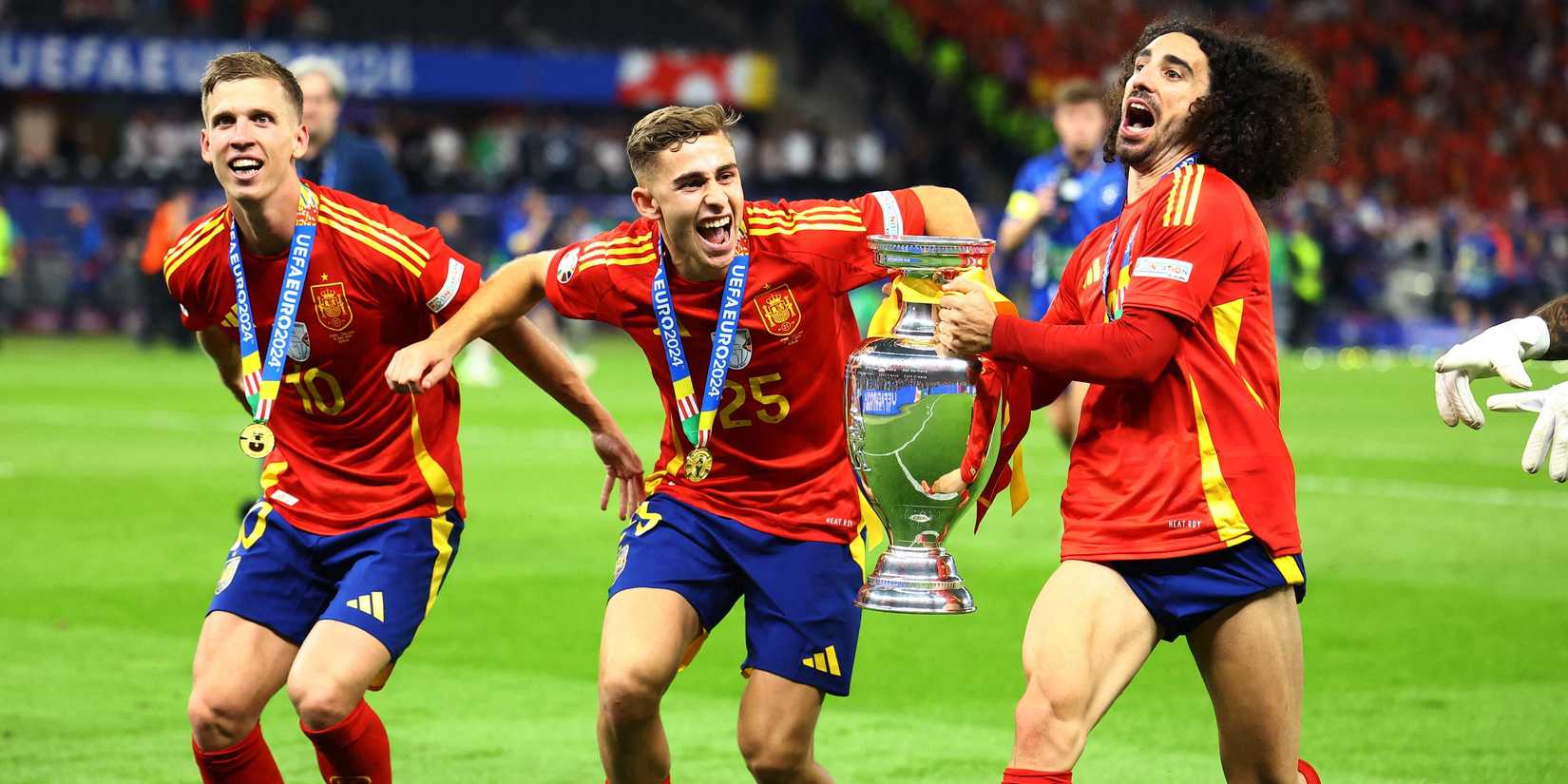 Spain's Dani Olmo, Marc Cucurella and Fermin Lopez celebrate with the trophy after winning the final