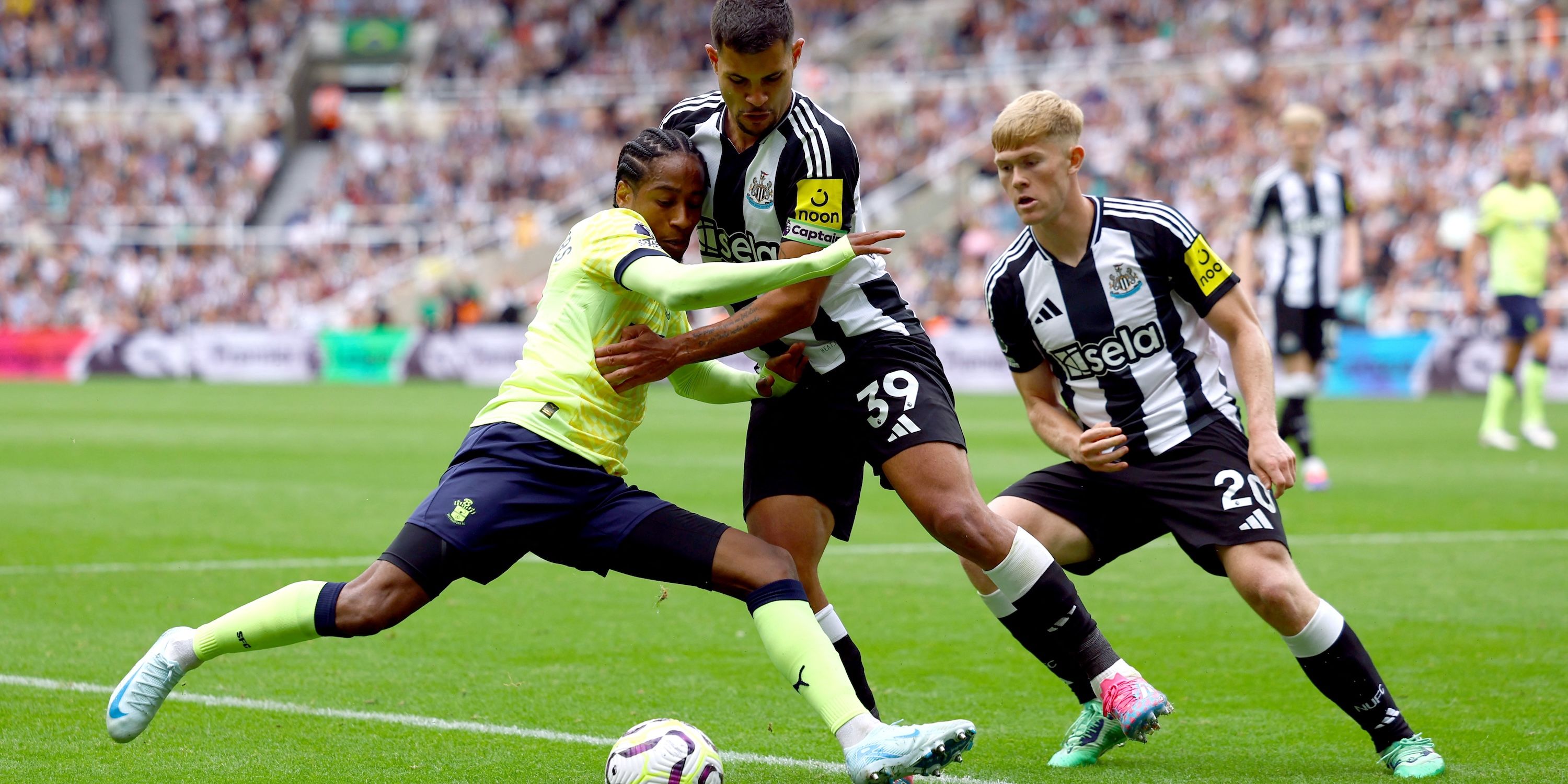 Lewis Hall of Newcastle United and Bruno Guimaraes from Newcastle United in action with Kyle Walker-Peters from Southampton