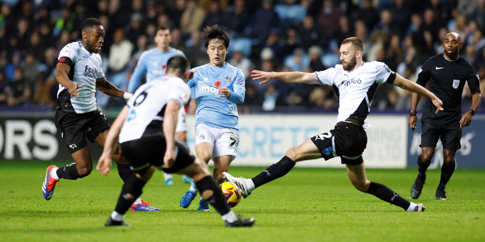 Tatsuhiro Sakamoto, do Coventry City, em ação com Ebou Adams e Nathaniel Phillips, do Derby County