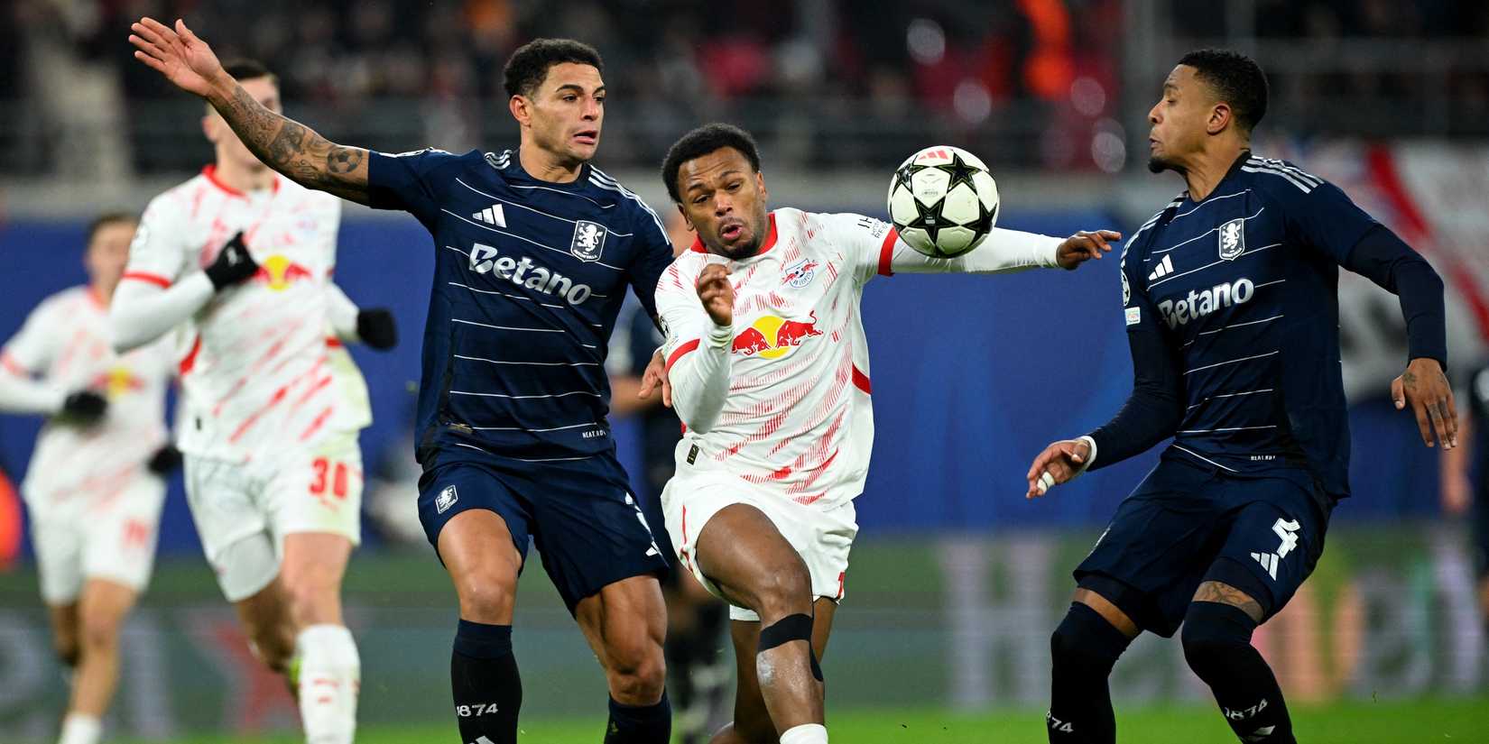 Diego Carlos e Ezri Konsa, do Aston Villa, em ação com Lois Openda, do RB Leipzig